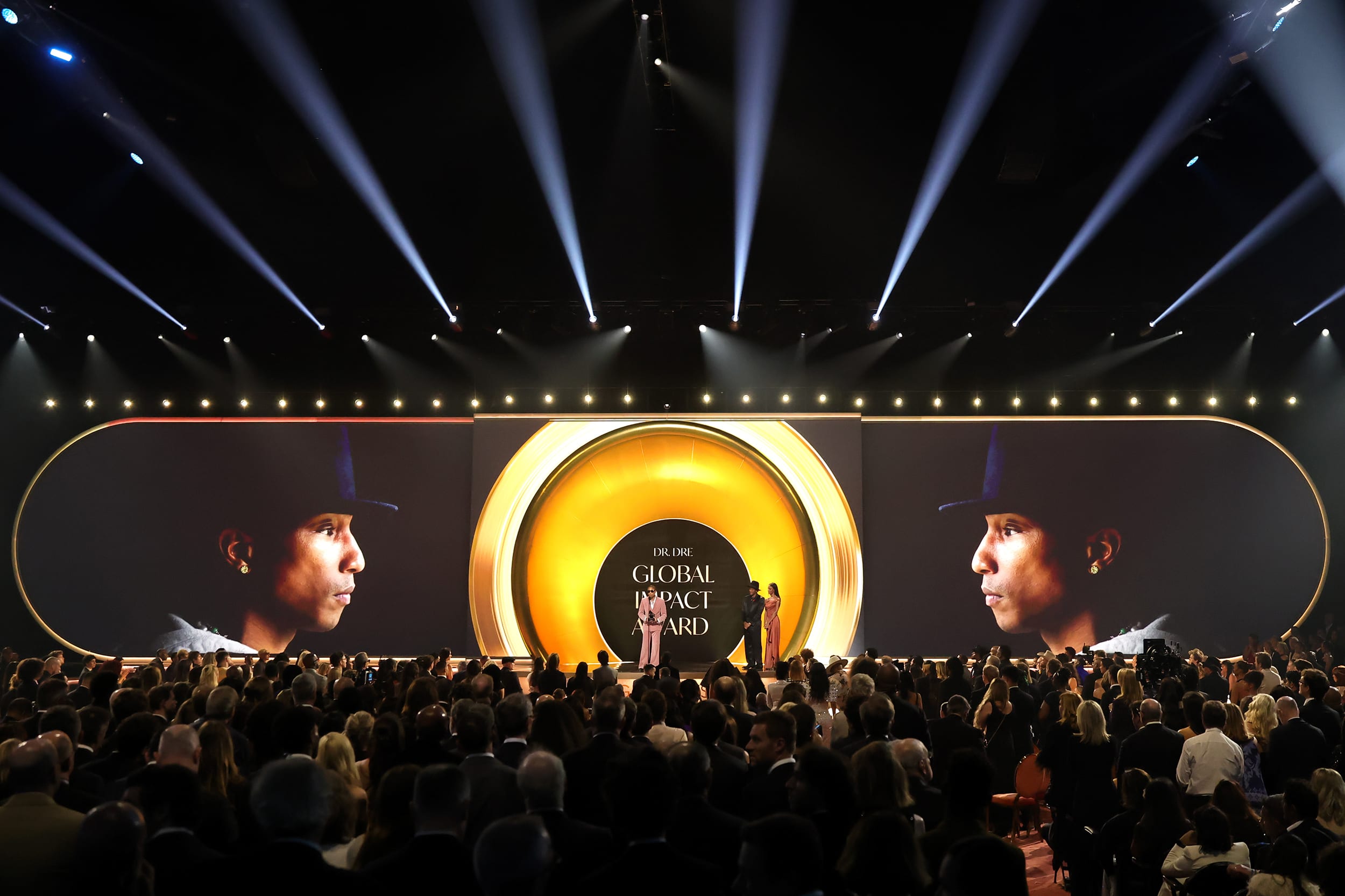 A wide view of the Grammy stage with Pharrell Williams' face projected onto the stage backdrop.
