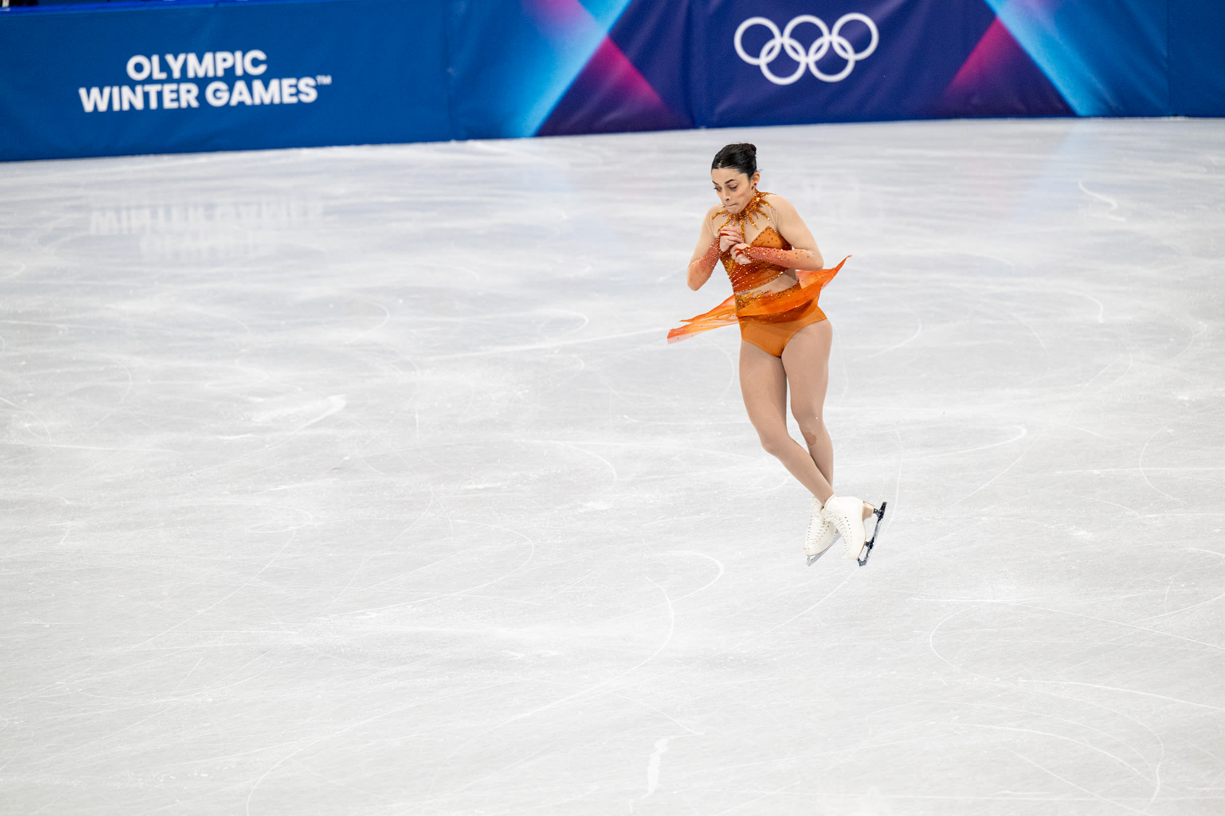 Madeline Schizas twirls in the air over ice during an Olympic competition
