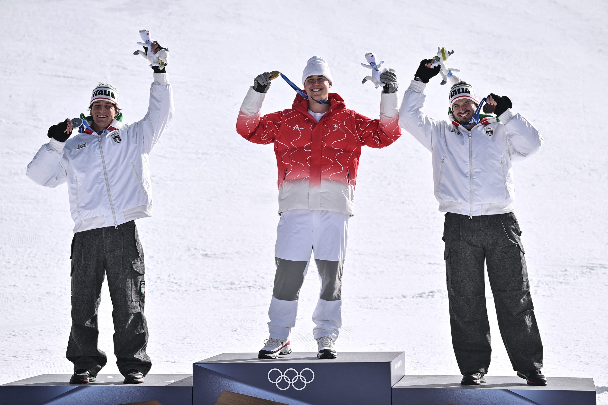 Men's downhill winner Switzerland's Franjo von Allmen center, silver medallist Italy's Giovanni Franzoni left and bronze medallist Italy's Dominik Paris right, on the podium in Bormio, Italy on Feb. 7, 2026. 