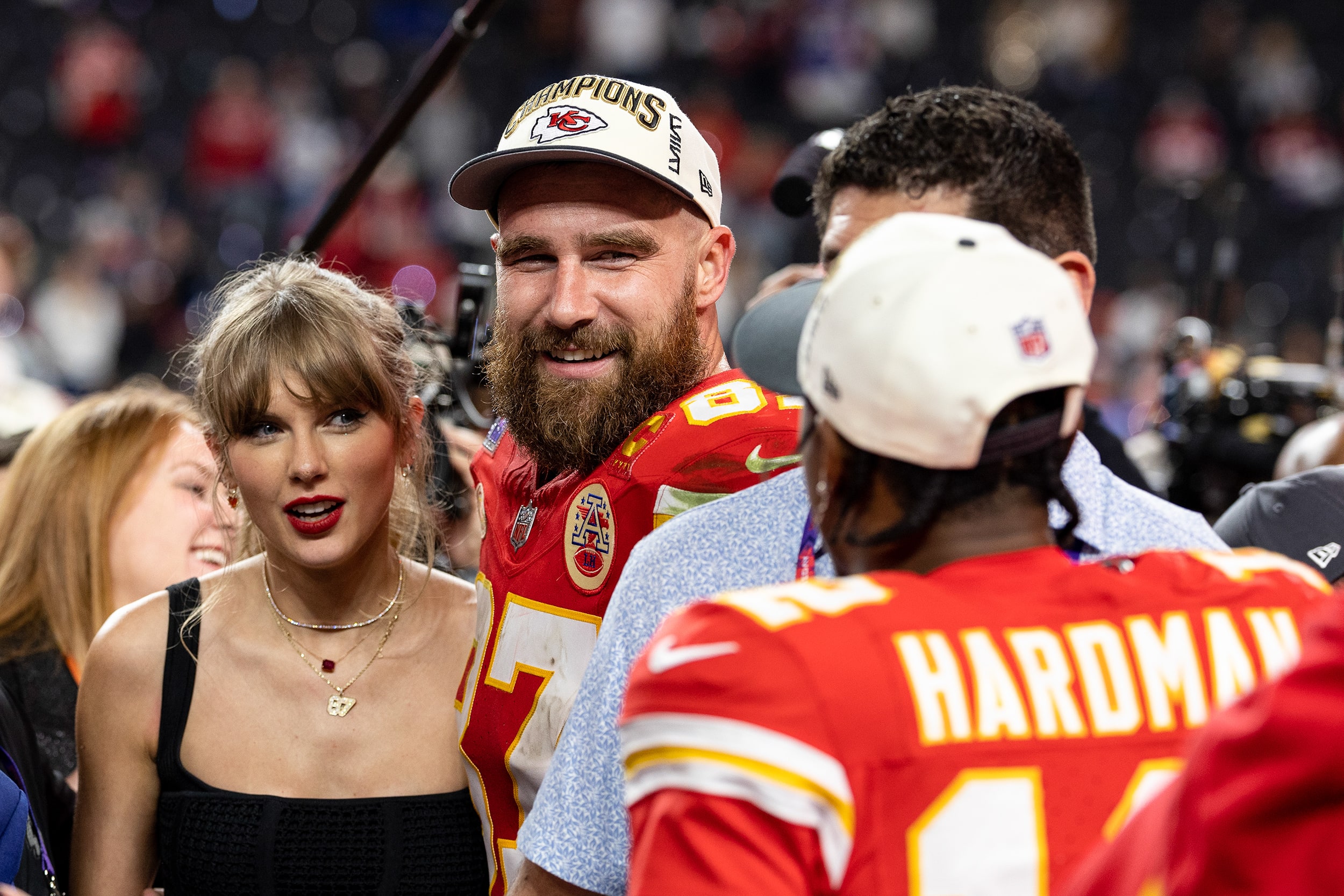 Travis Kelce and Taylor Swift together on the football field following a Kansas City Chiefs game