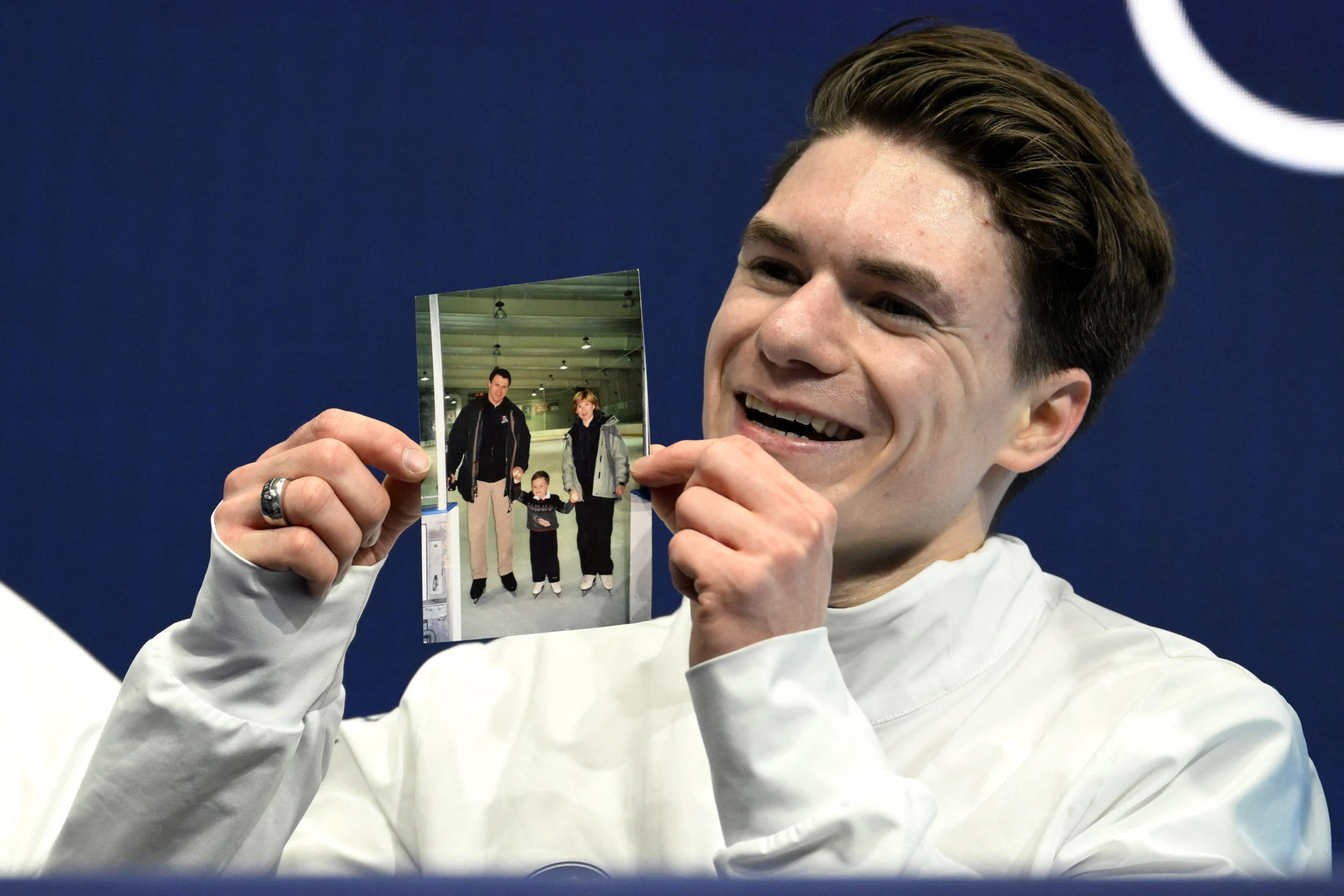 USA's Maxim Naumov holds a picture of his parents