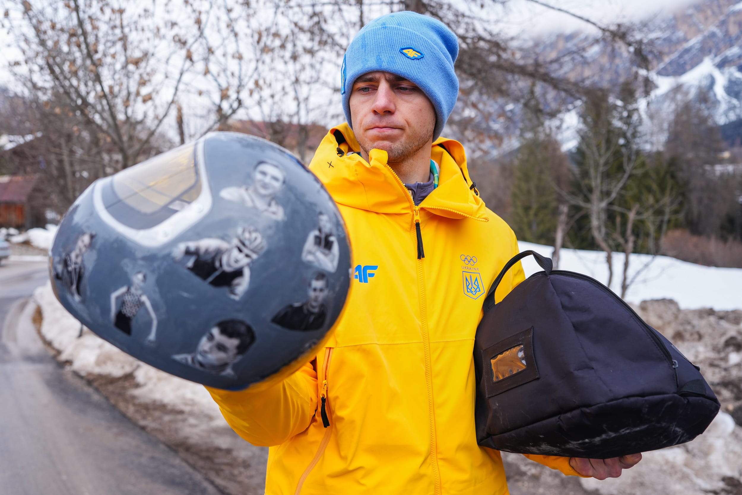 Ukraine's Vladyslav Heraskevych, holding his helmet featuring pictures.