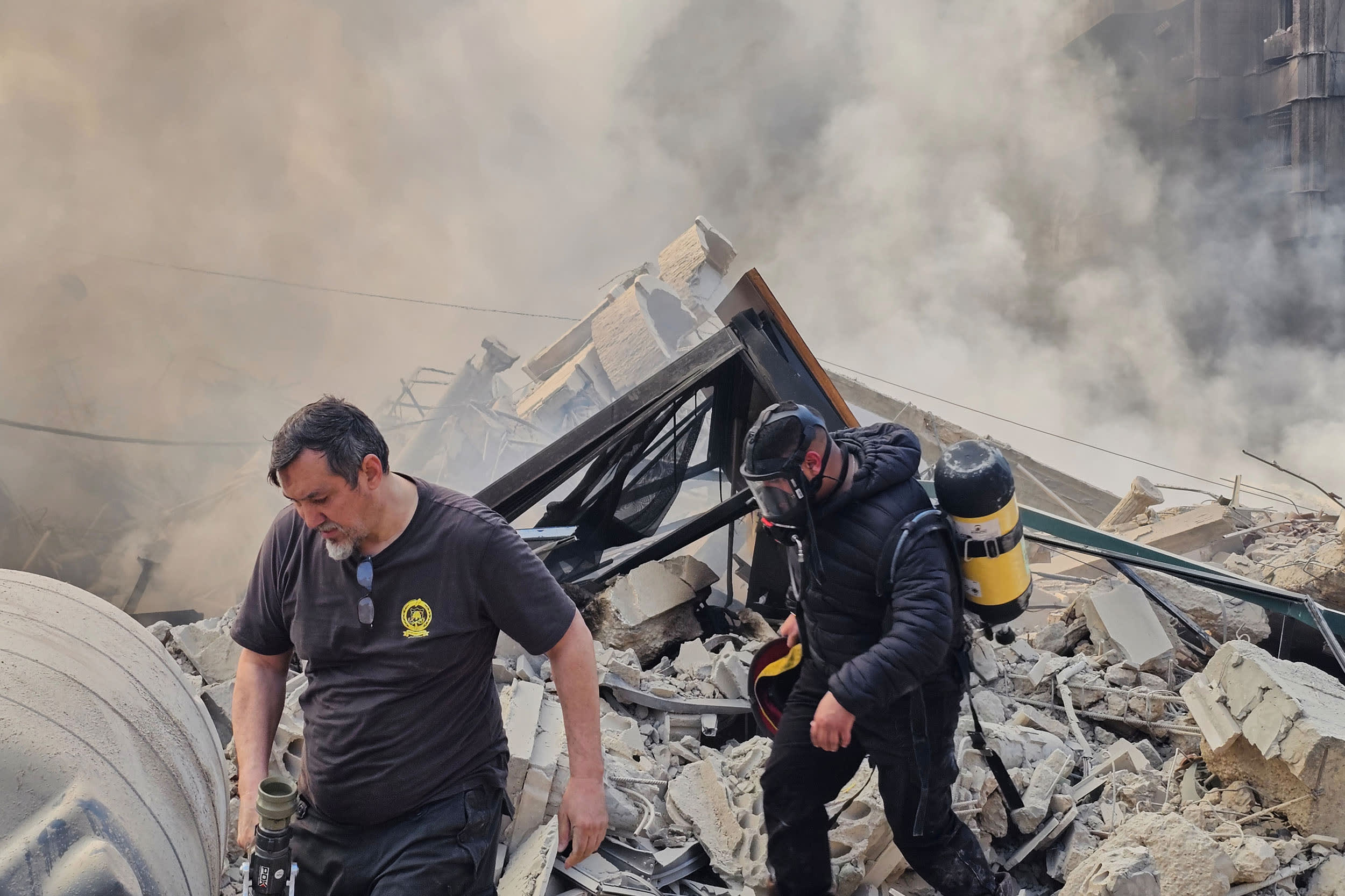Firefighters inspect the rubble of a building hit by an Israeli airstrike in Dahiyeh, a southern suburb of Beirut, Lebanon, Tuesday, March 3, 2026.