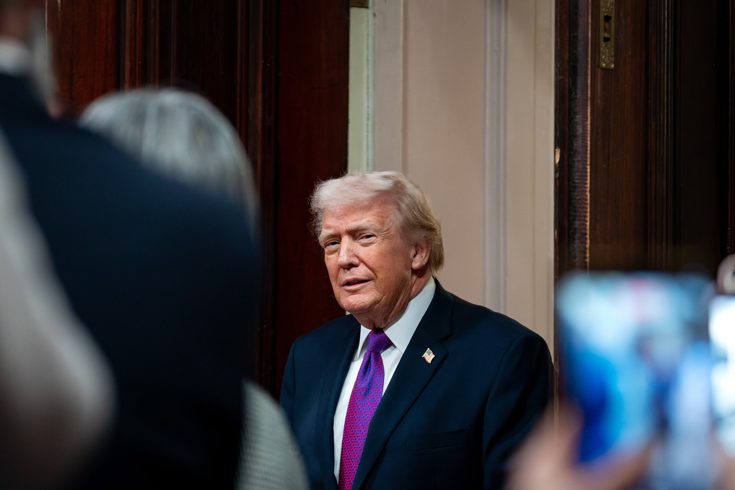 Donald Trump smiles while looking toward the camera.