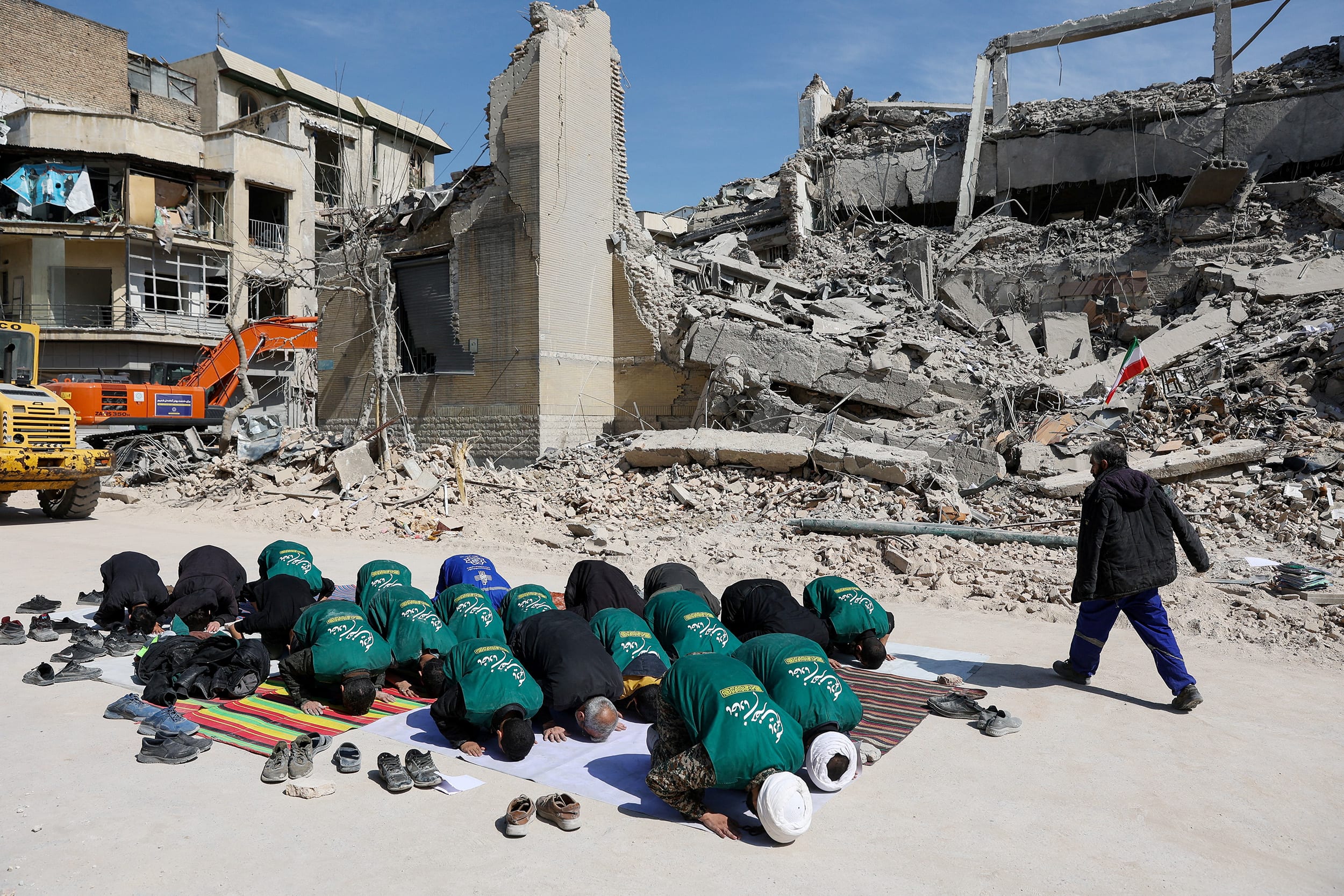 Volunteers from the group Servants of the Lady Zahra are seen praying next to the ruins of a destroyed police station in Tehran on Wednesday. 