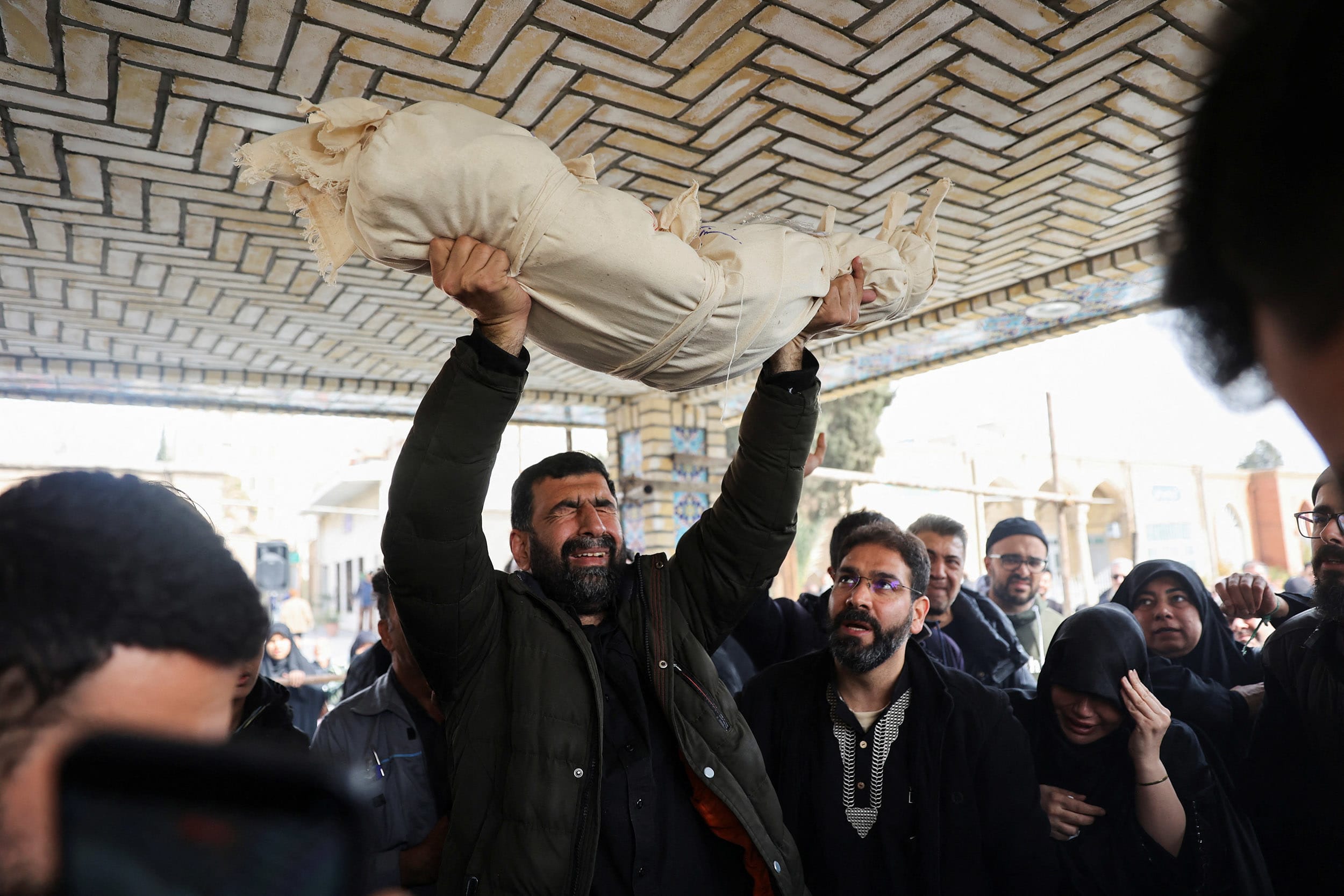 People attend the funeral of Zainab Sahebi, a two-year-old child who was killed in a strike, amid the U.S.-Israeli conflict with Iran, in Tehran