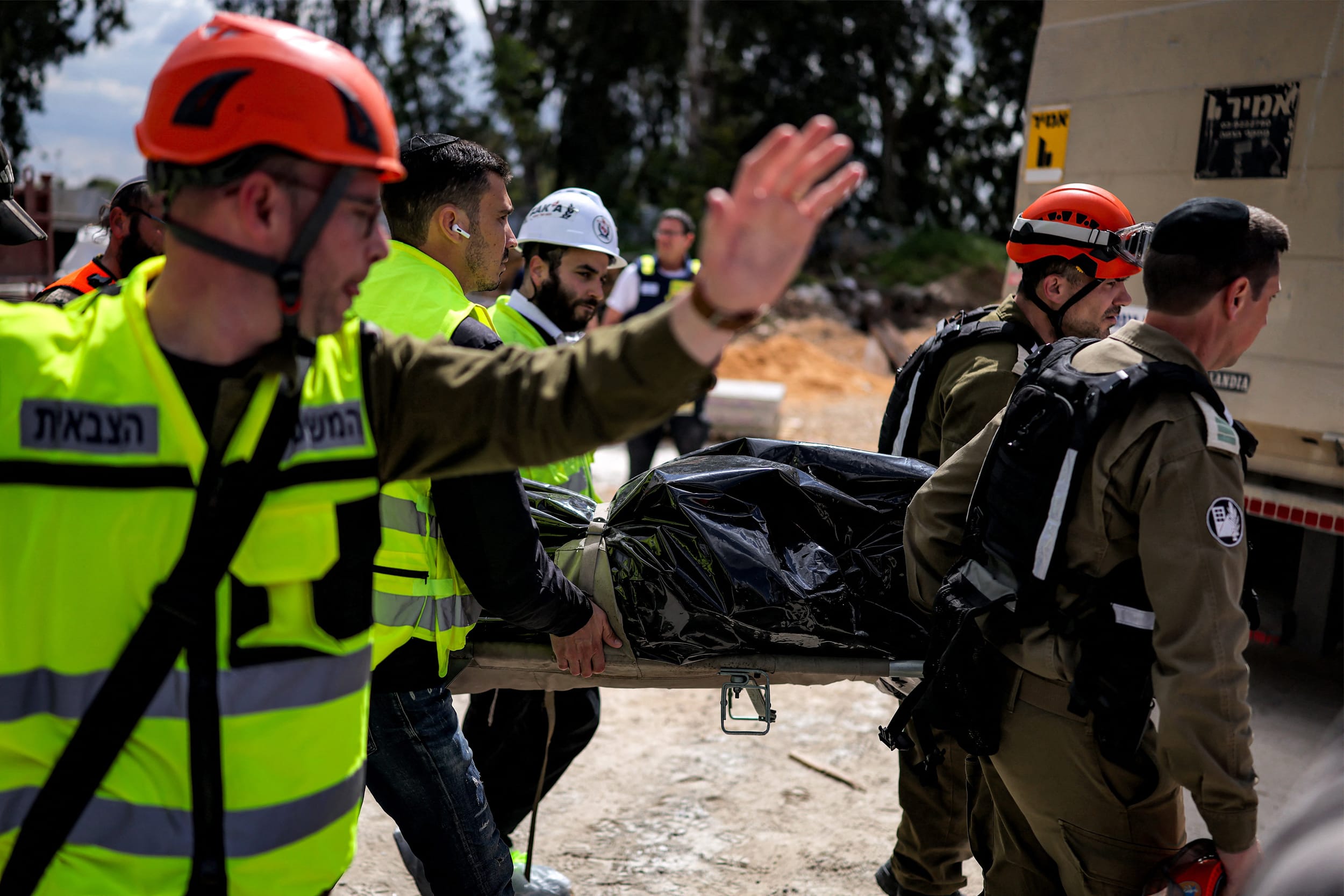Civil defence forces carry away the body of a victim killed from the impact of an Iranian projectile in Yehud, Israel on March 9, 2026. 