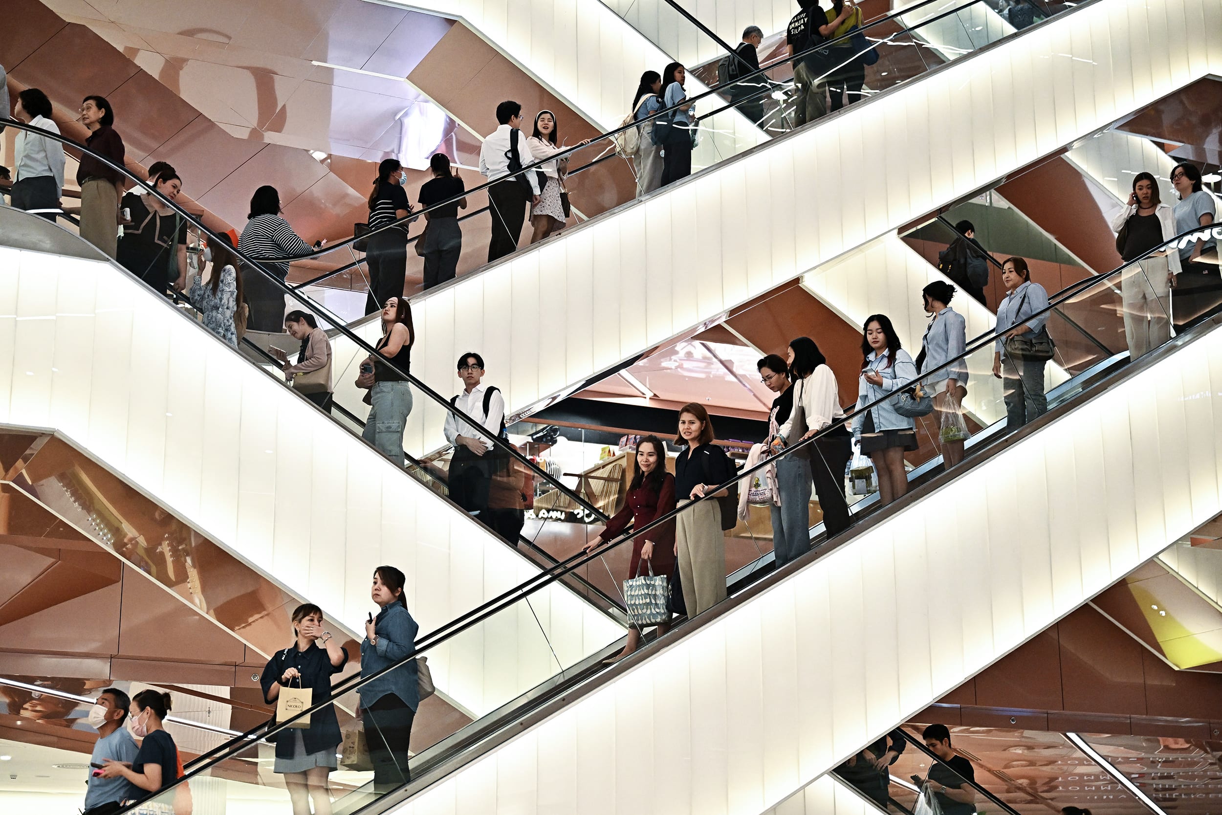 Image: Dozens of people stood on numerous escalators 