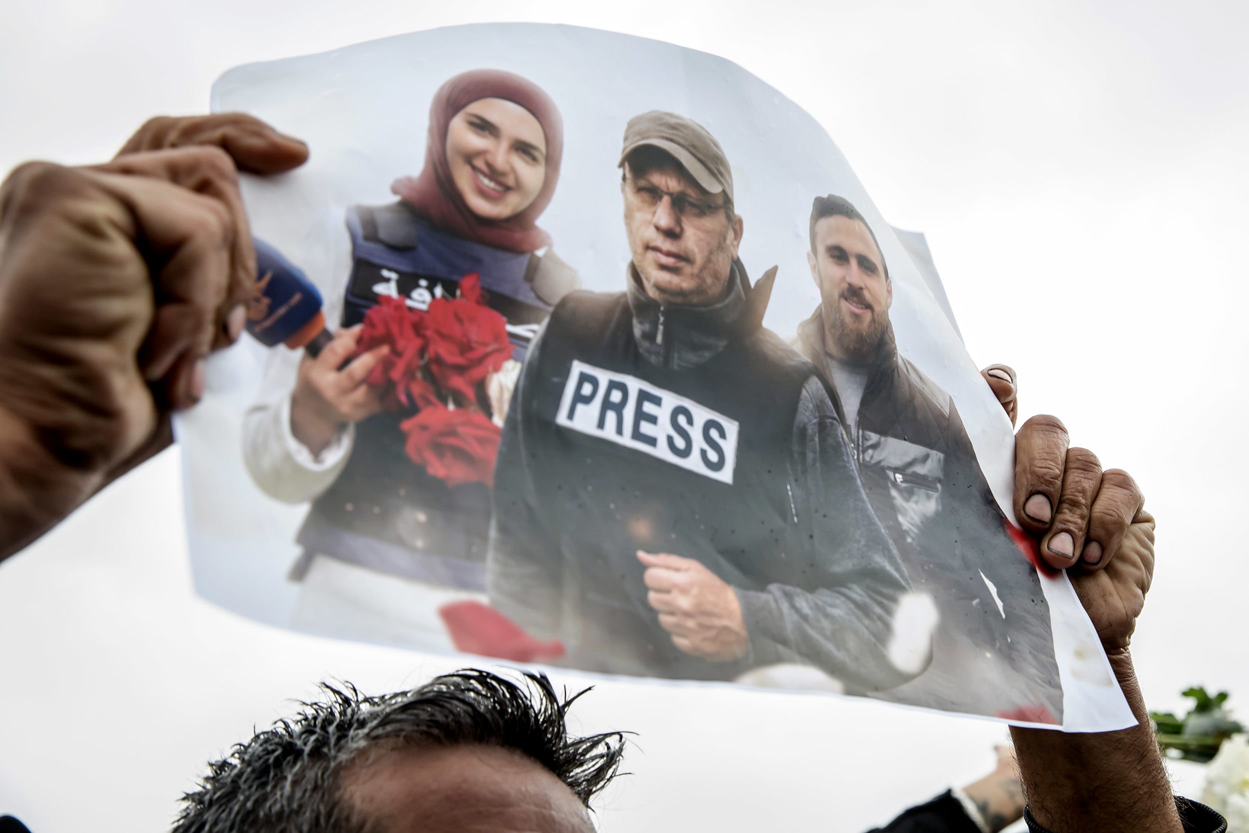 A poster is held up during a funeral ceremony in Choueifat,