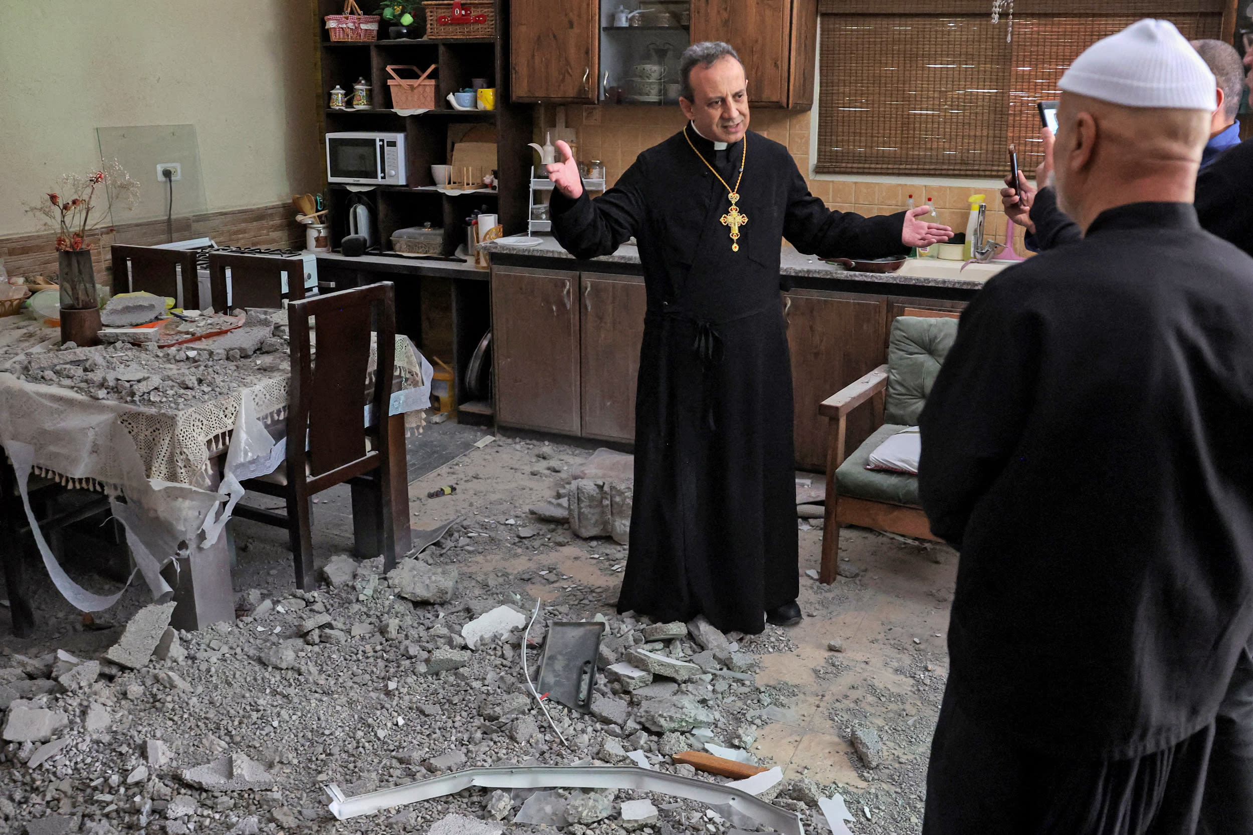 Monsignor Simon Khoury, a local Greek Melkite Catholic parish priest, visits residents whose house was damaged by a strike in Shefa-Amr in northern Israel on March 30, 2026.