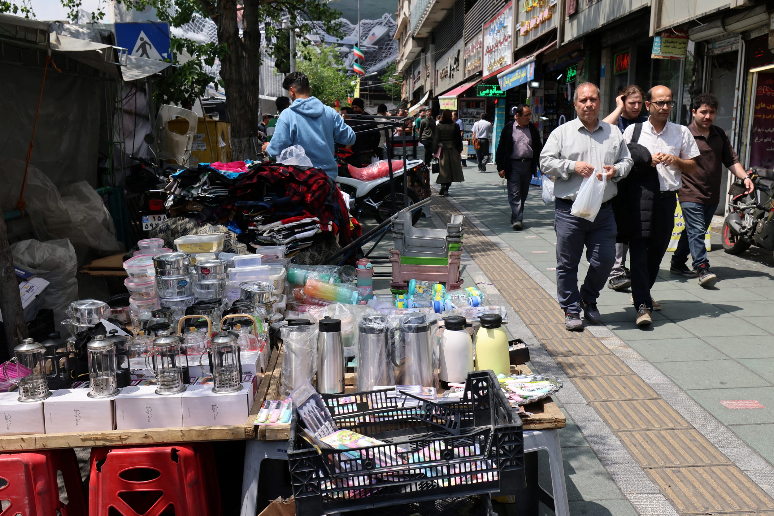 Pedestrians pass street vendors in Tehran on April 22, 2026.