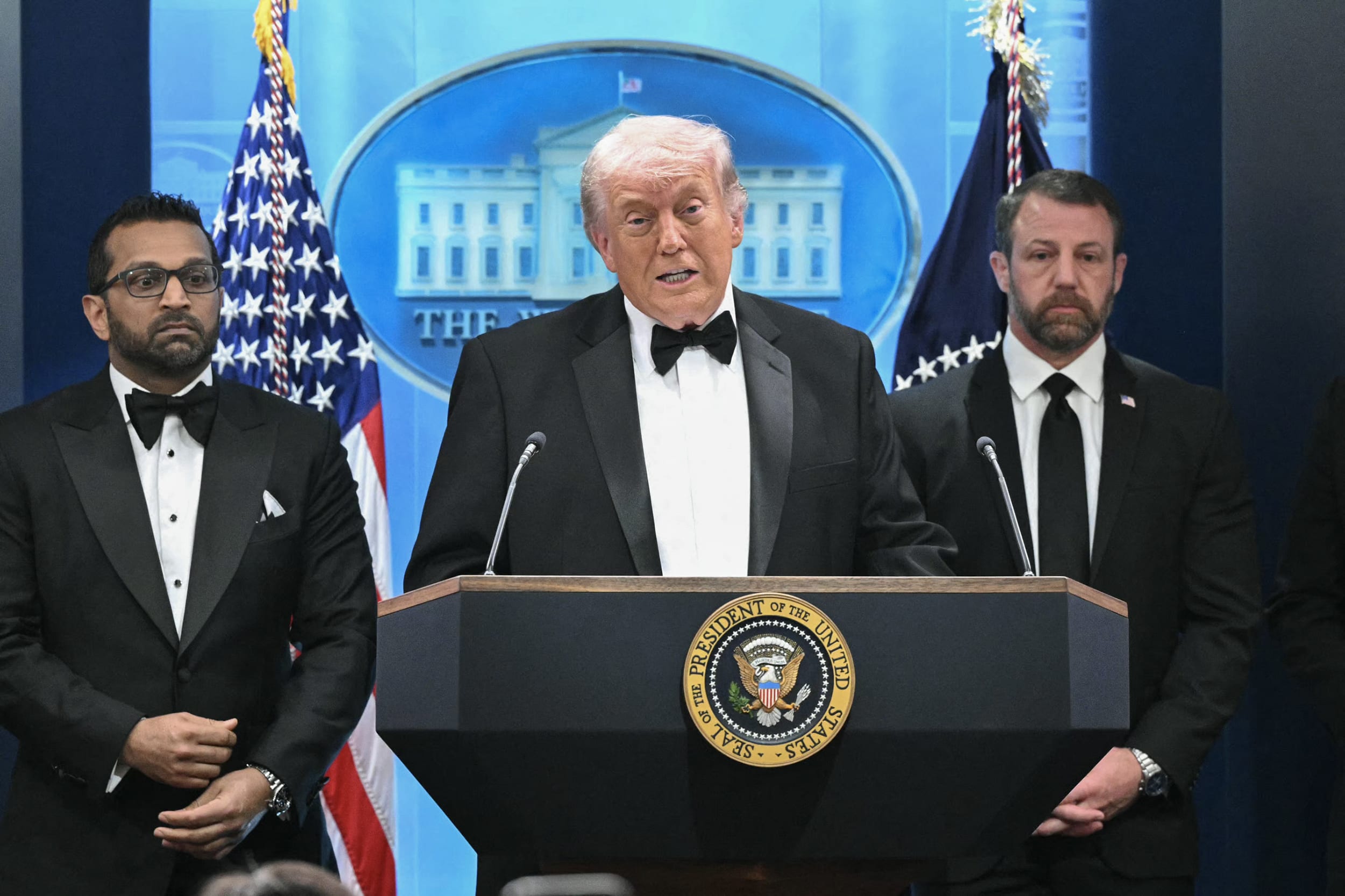Donald Trump at a lectern at the White House with Kash Patel and Markwayne Mullin standing behind him.