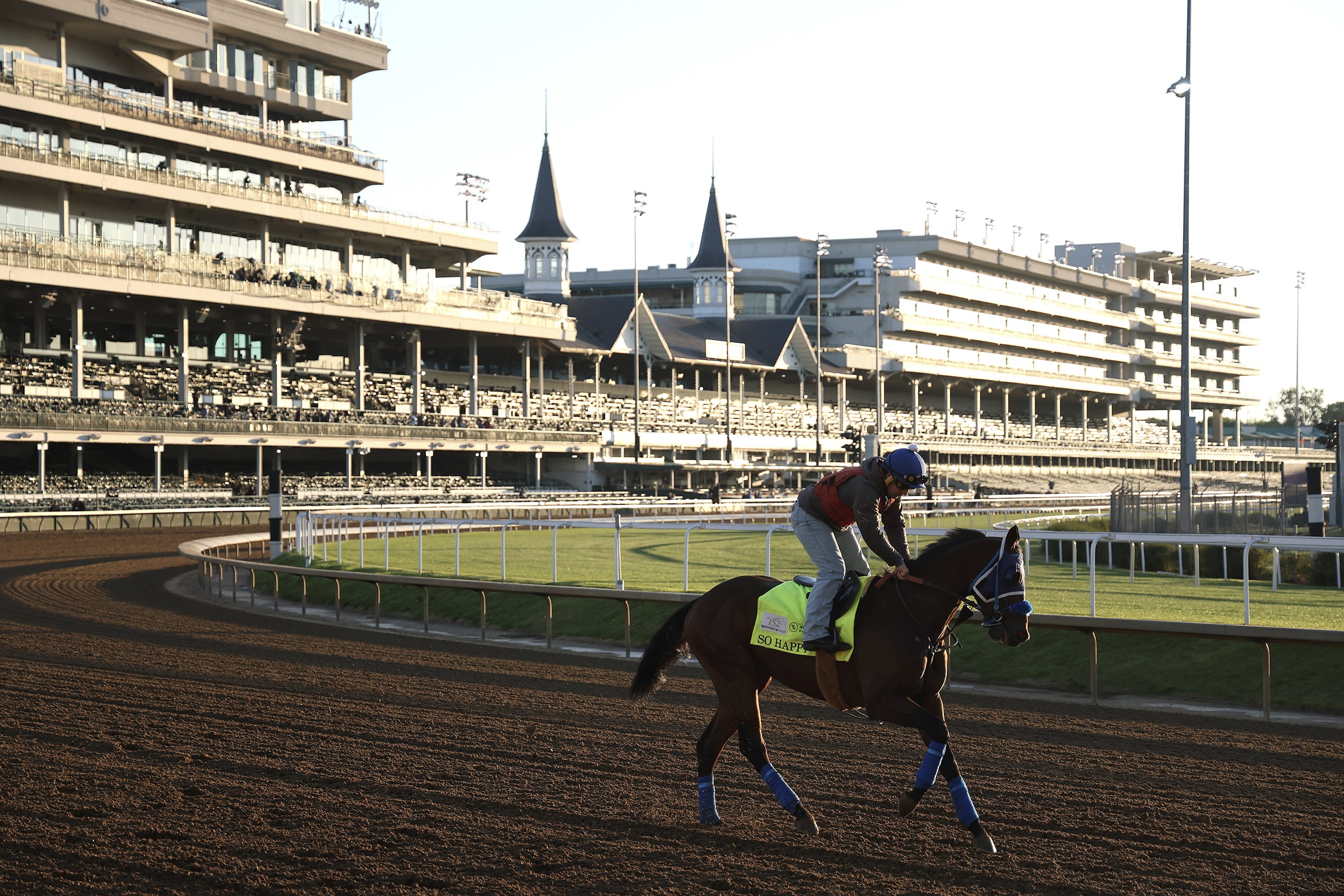 A jockey riding a horse in early morning light.
