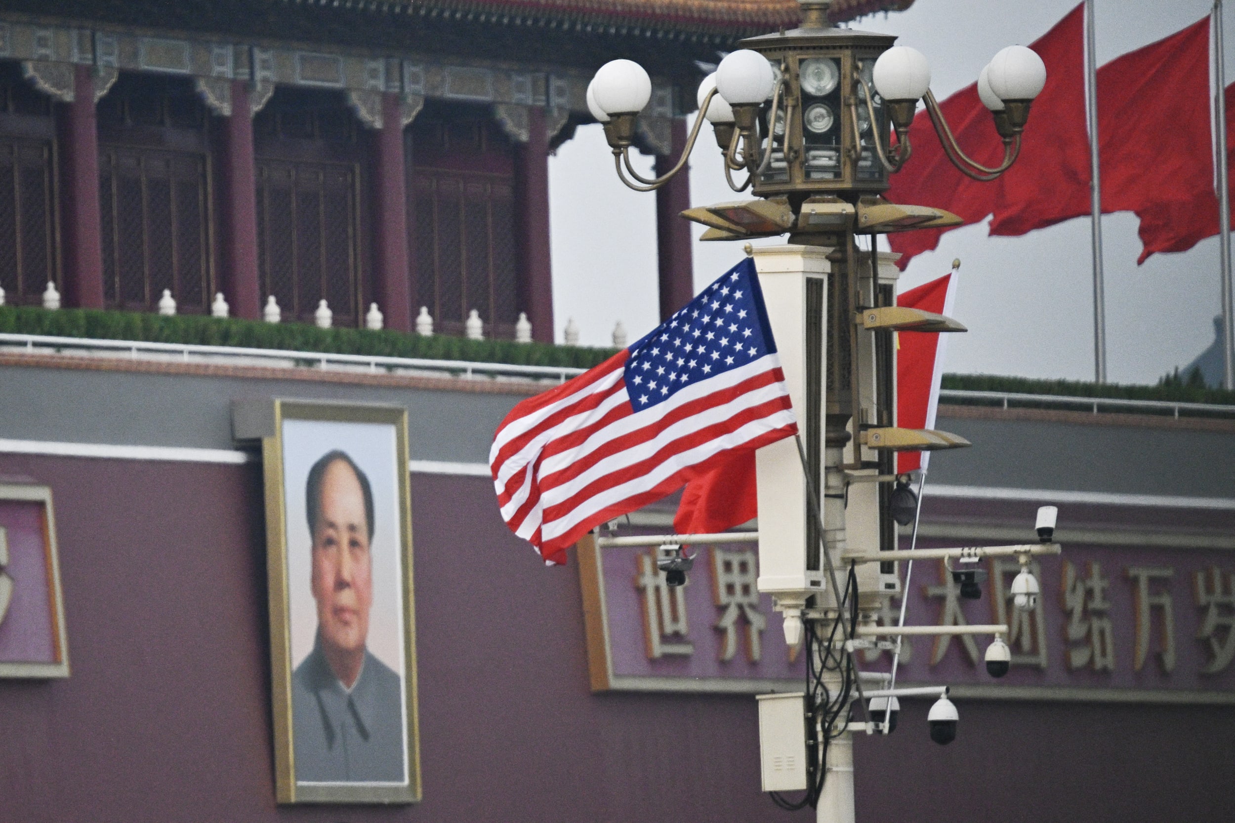 A U.S. flag hangs in front of a portrait of late communist leader Mao Zedong at Tiananmen Gate