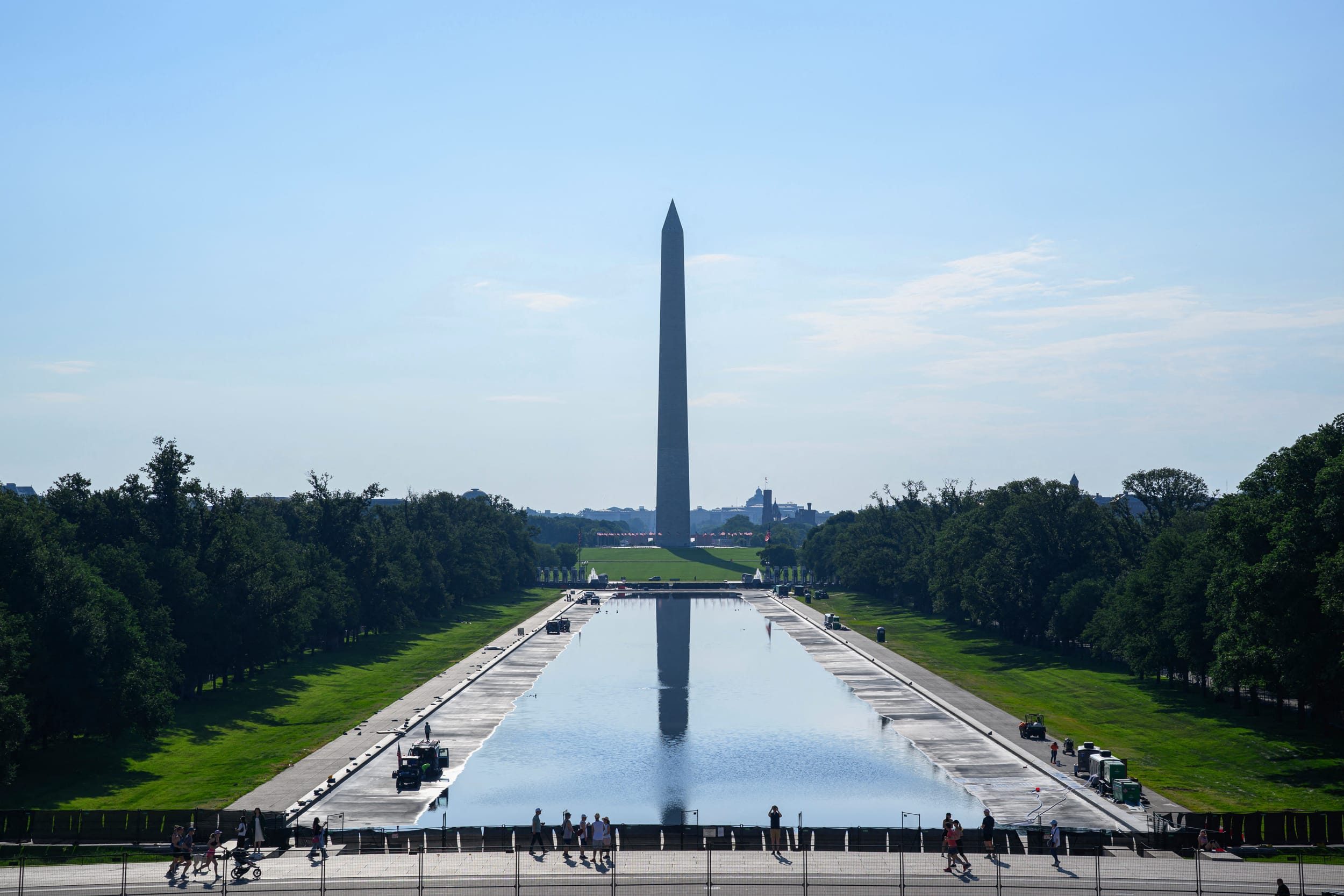 Visitors walk past the partially filled Lincoln Memorial Reflecting Pool