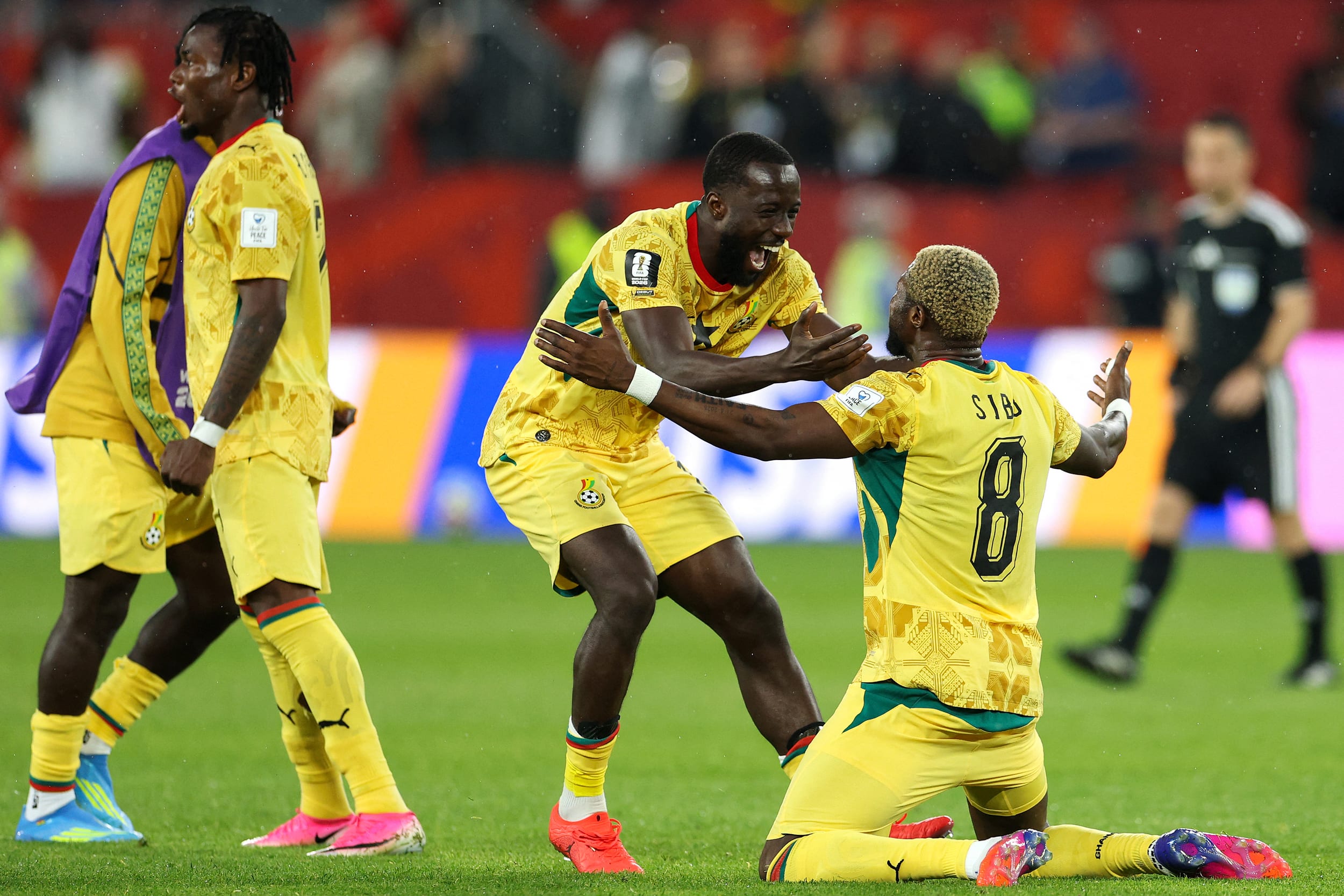Ghana's midfielder #08 Kwasi Sibo celebrates with teammate midfielder #15 Elisha Owusu after winning.