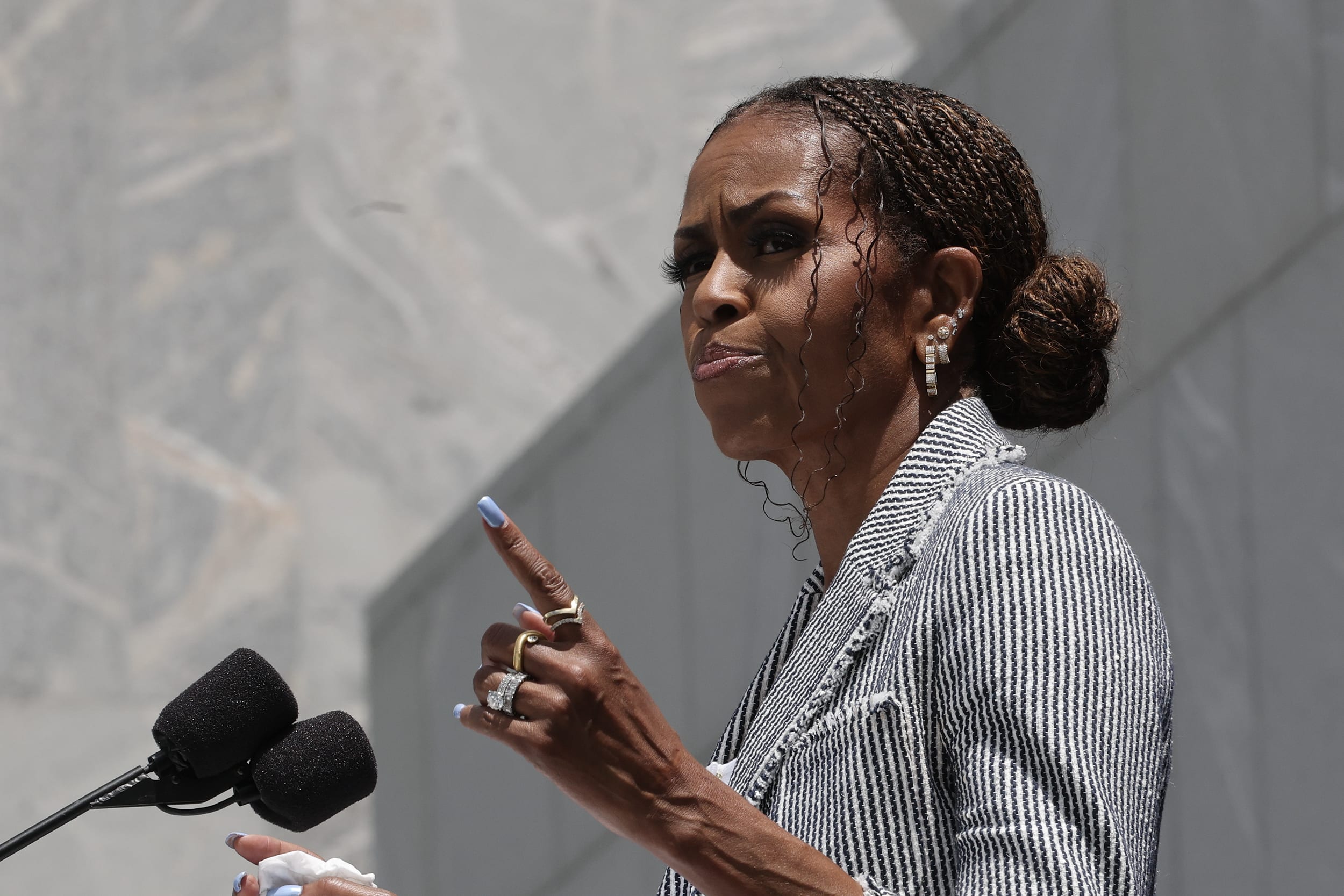 Michelle Obama speaking outdoors at a podium.