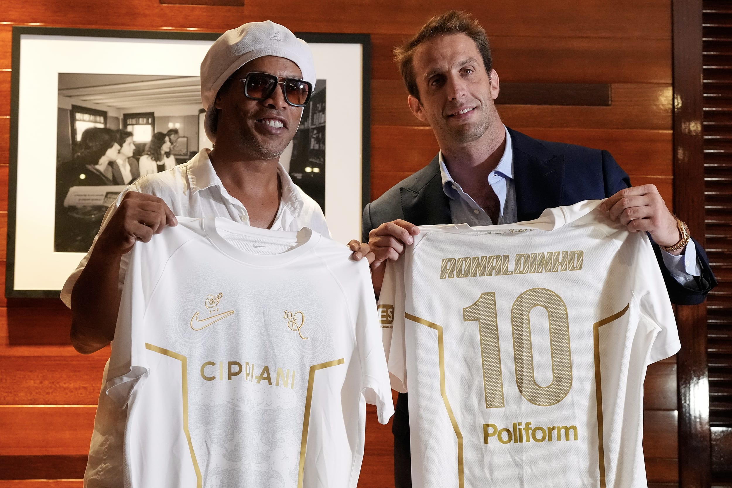 Ronaldinho and Ignazio Cipriani hold up white jerseys while posing for a photo