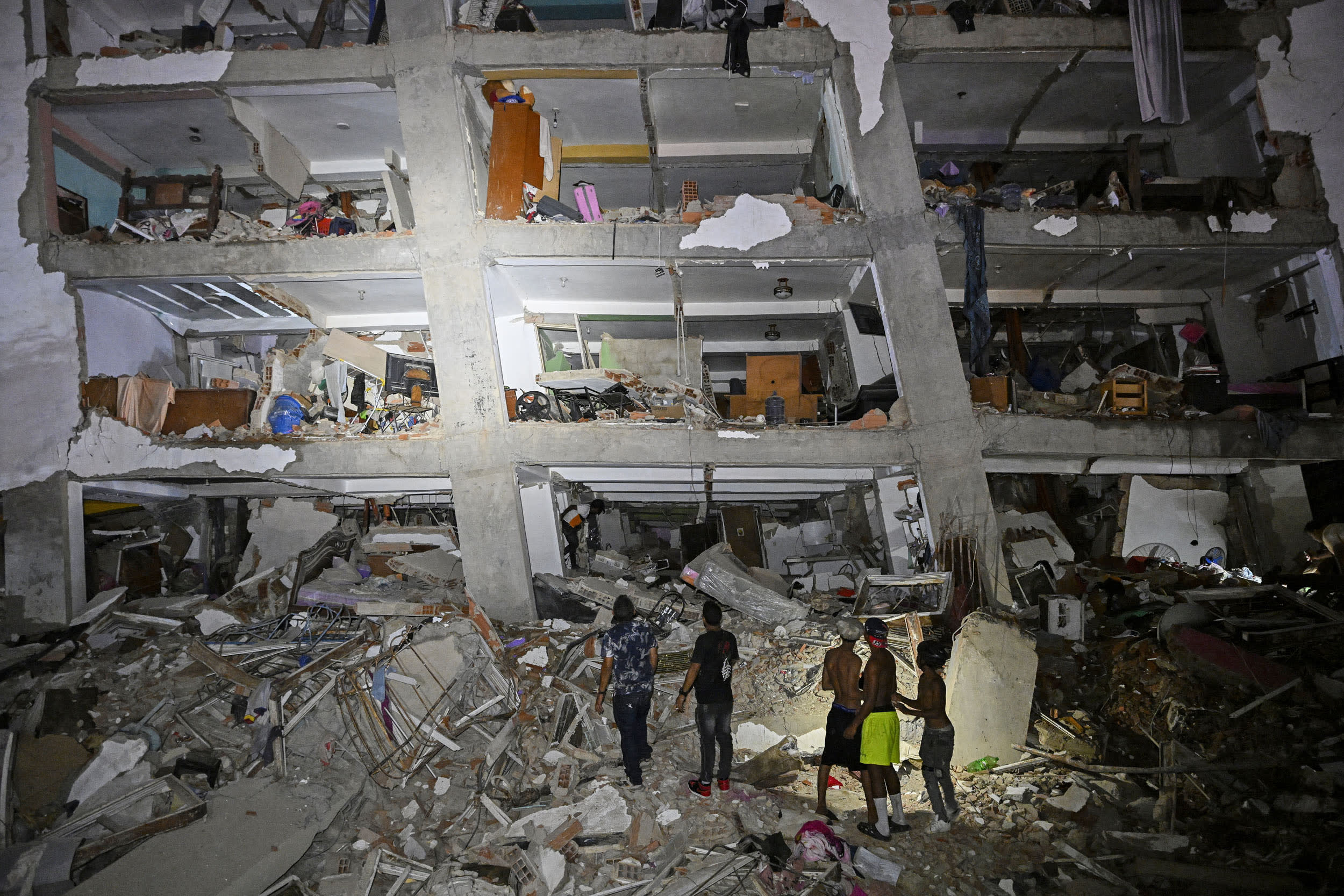 People stand in the rubble near a damaged building following an earthquake in Venezuela