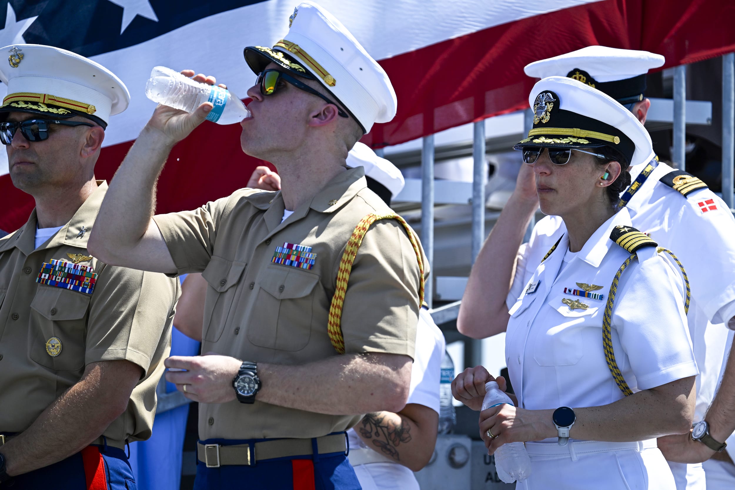 Members of the military drink water to keep cool.
