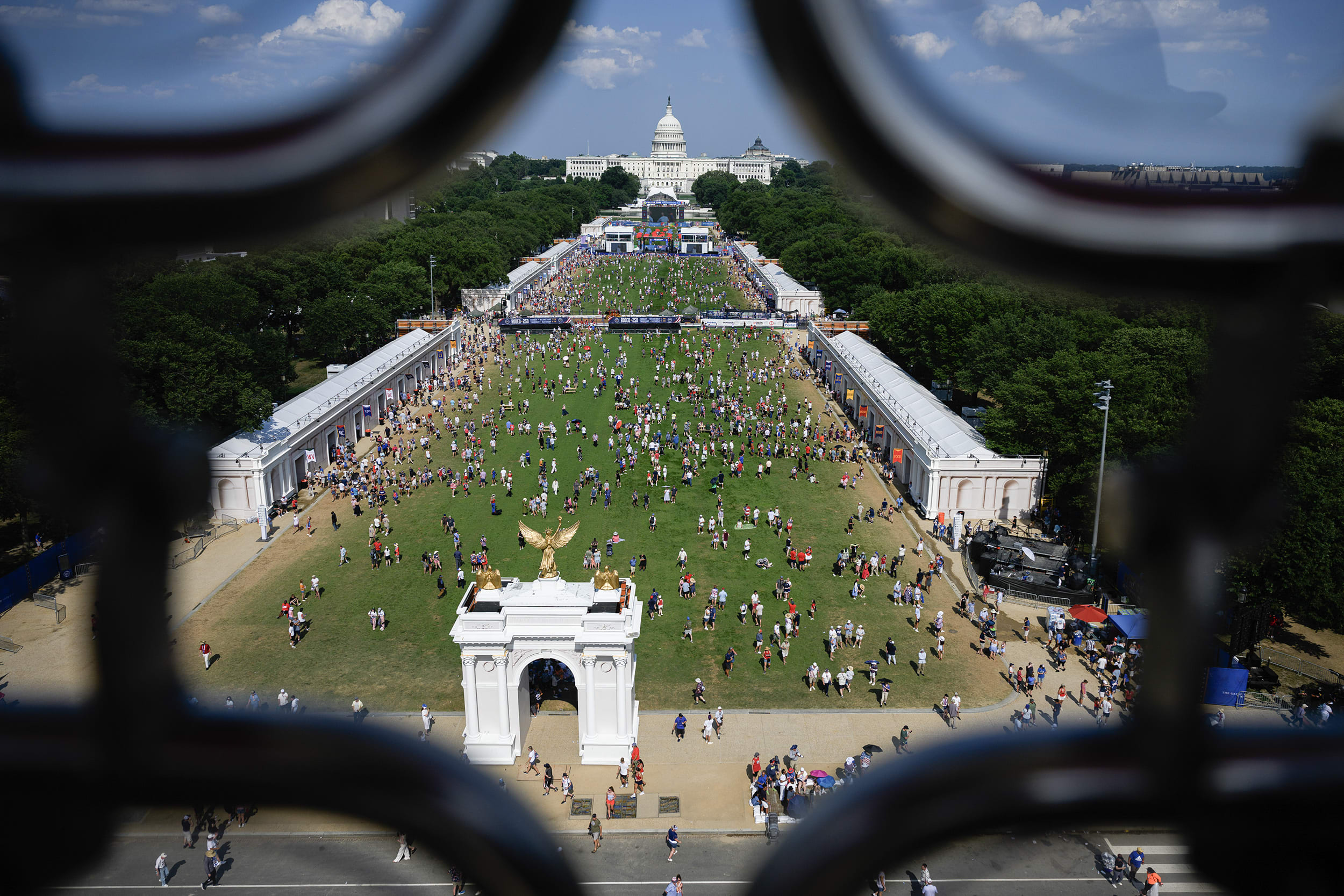An elevated view of the National Mall with hundreds of people on the lawn.