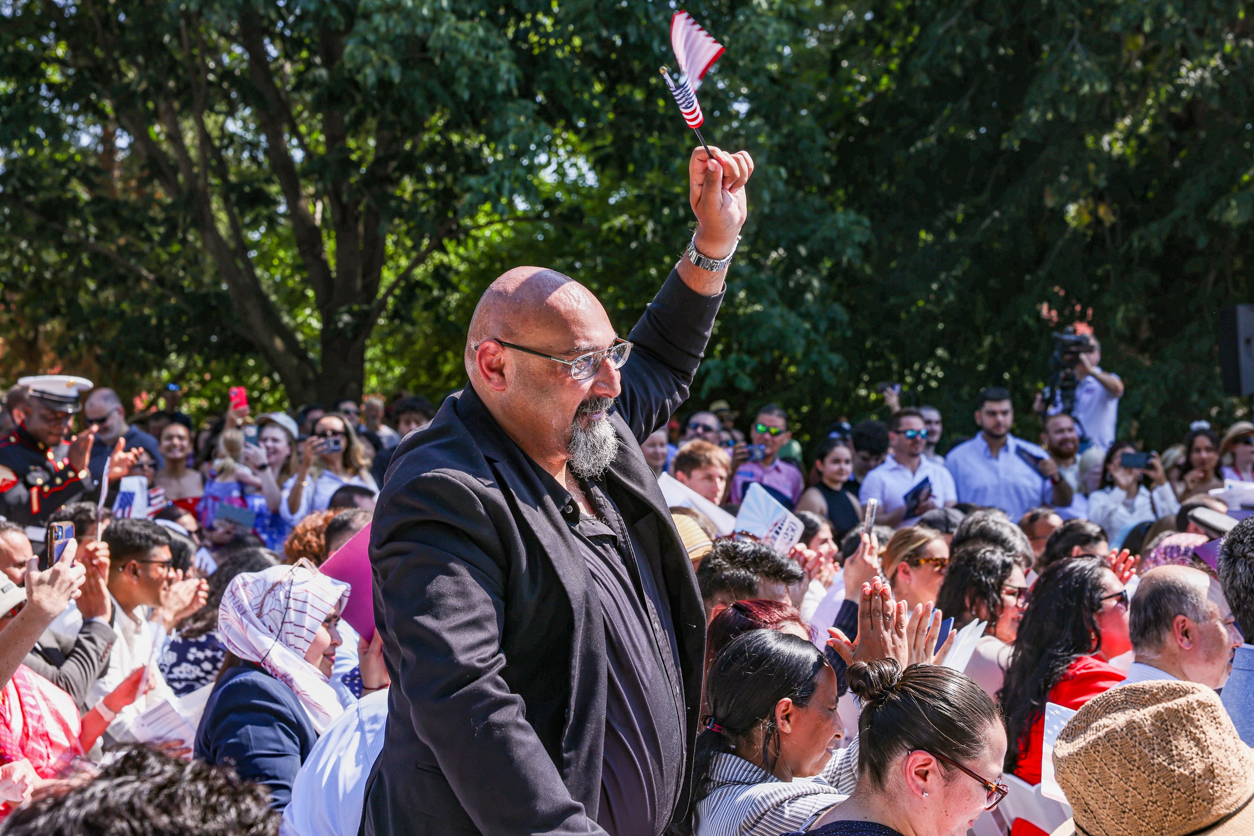 A new US citizen waves a U.S. flag during a naturalization ceremony.