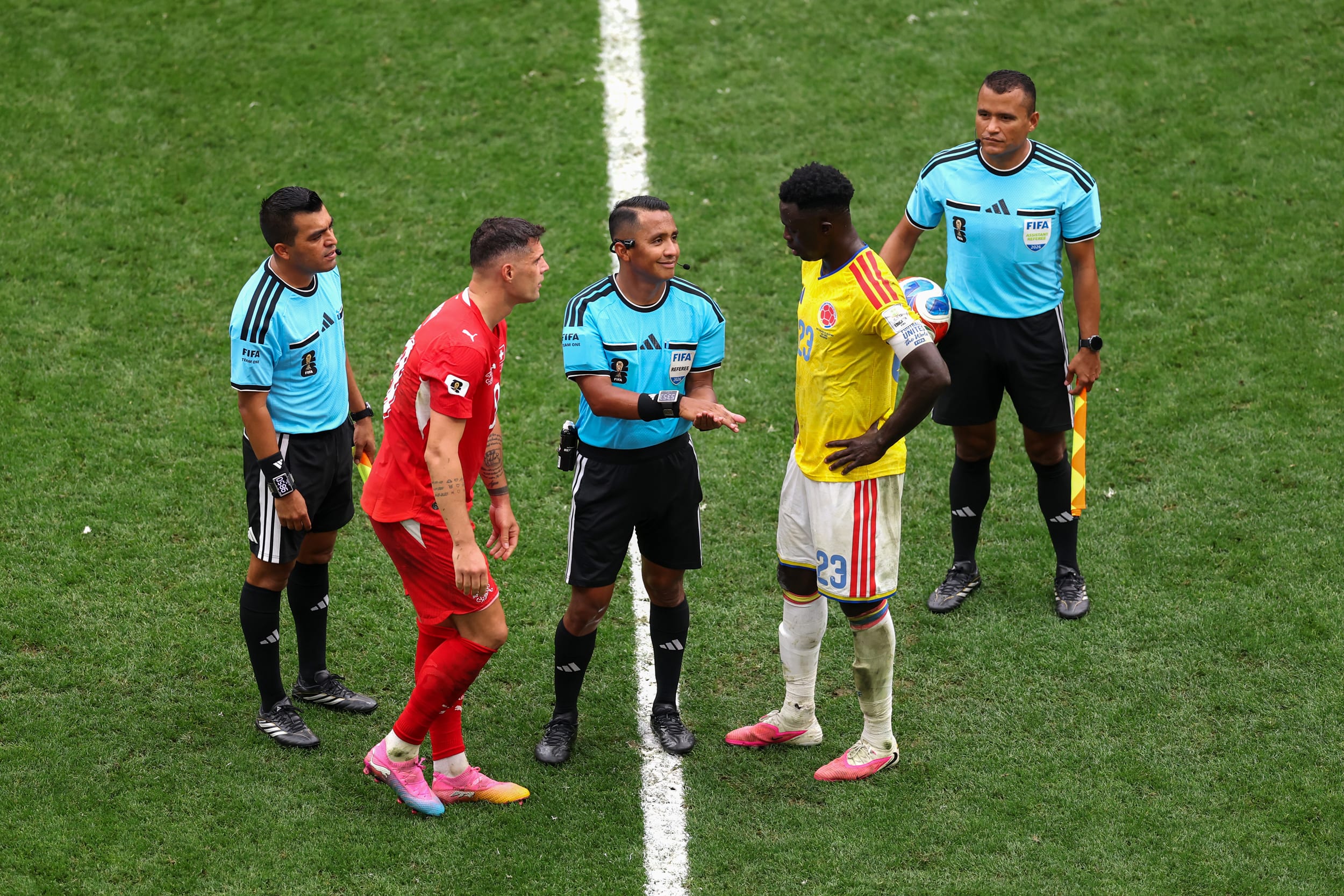 Referee Ivan Barton conducts the coin toss between Granit Xhaka #10 of Switzerland and Davinson Sanchez #23 of Colombia before the start of extra time during the Switzerland v Colombia game.