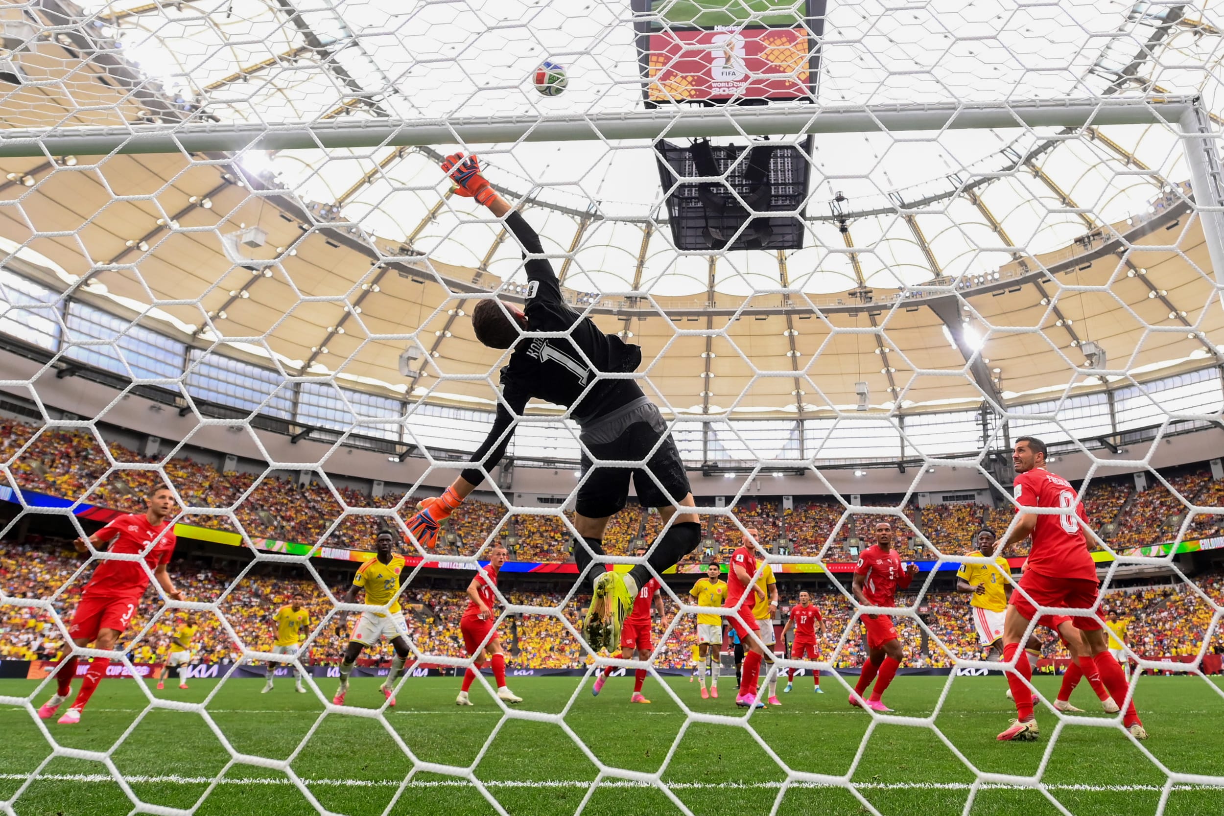Gregor Kobel #1 of Switzerland dives as the header of Jhon Lucumi # during the Switzerland v Colombia match.