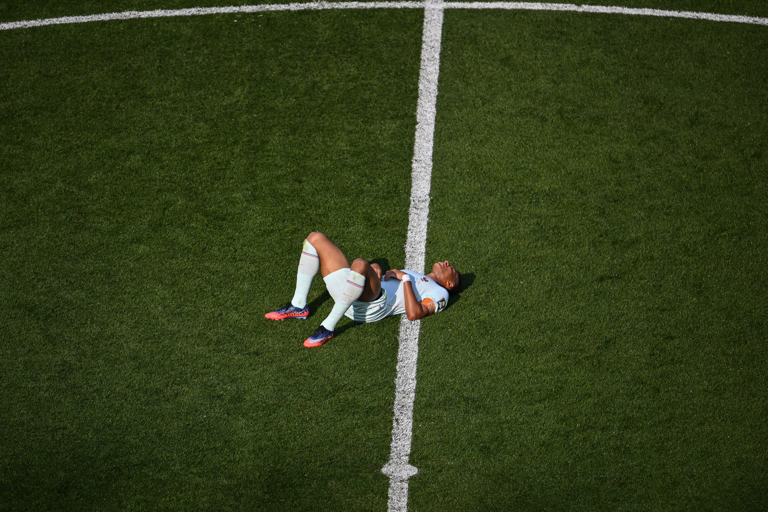 France's forward #10 Kylian Mbappe lies on the pitch during the 2026 World Cup football tournament quarter-final match between France and Morocco.