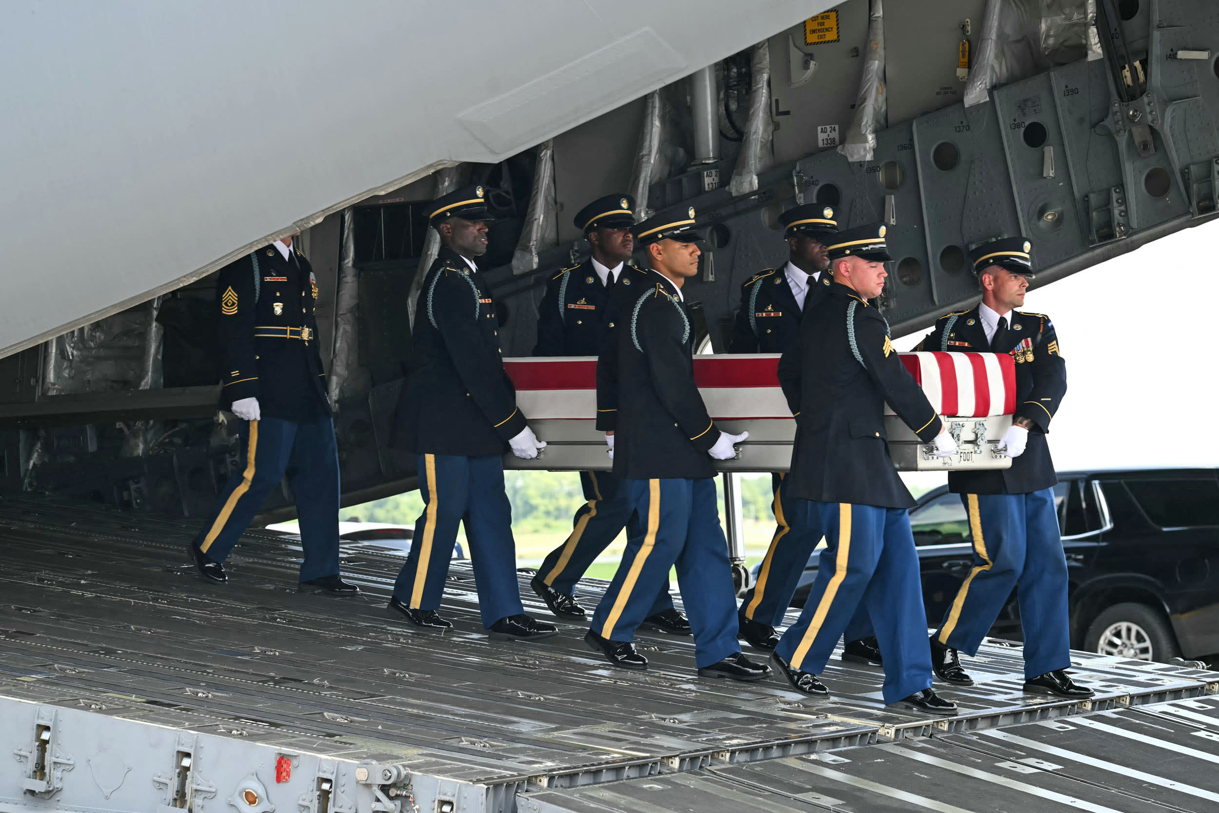 A U.S. Army carry team carries a flag-draped transfer case