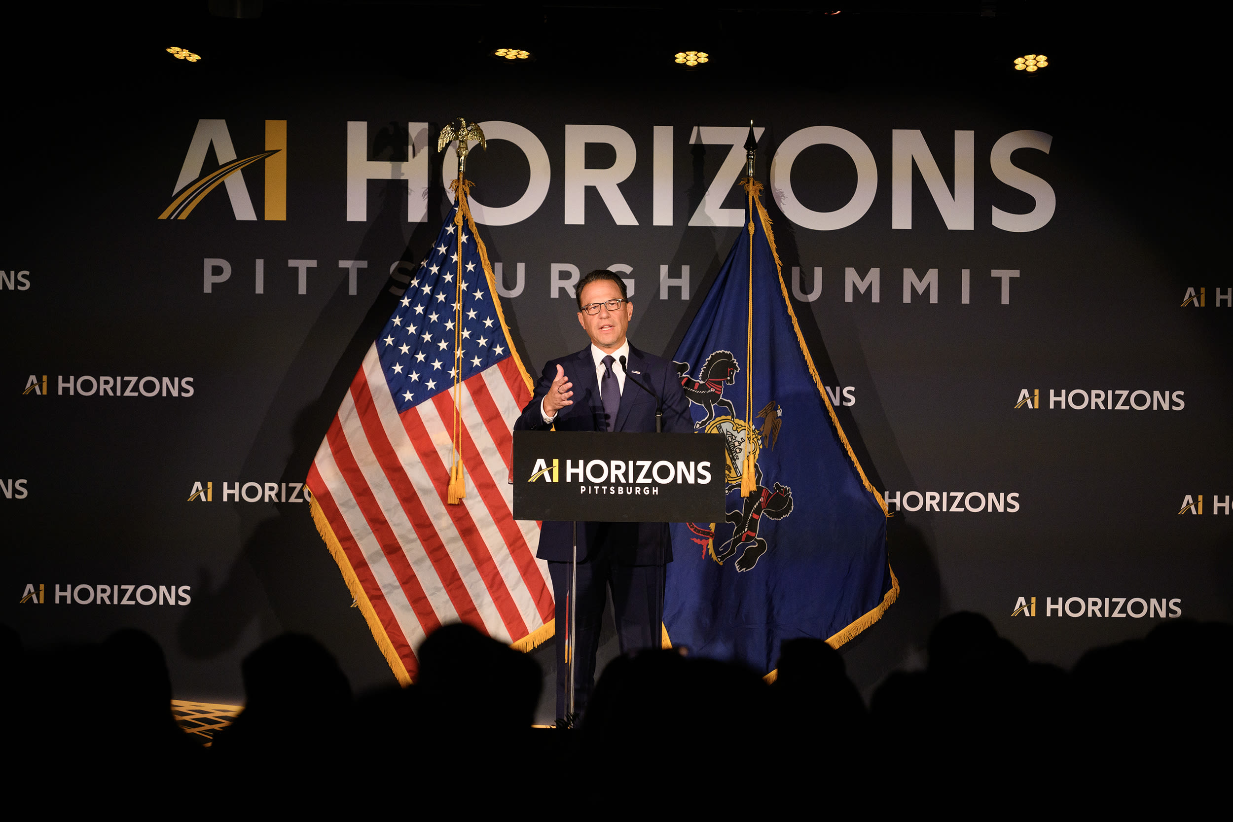 Pennsylvania Governor Josh Shapiro speaking at a lectern with signage reading AI HORIZONS.
