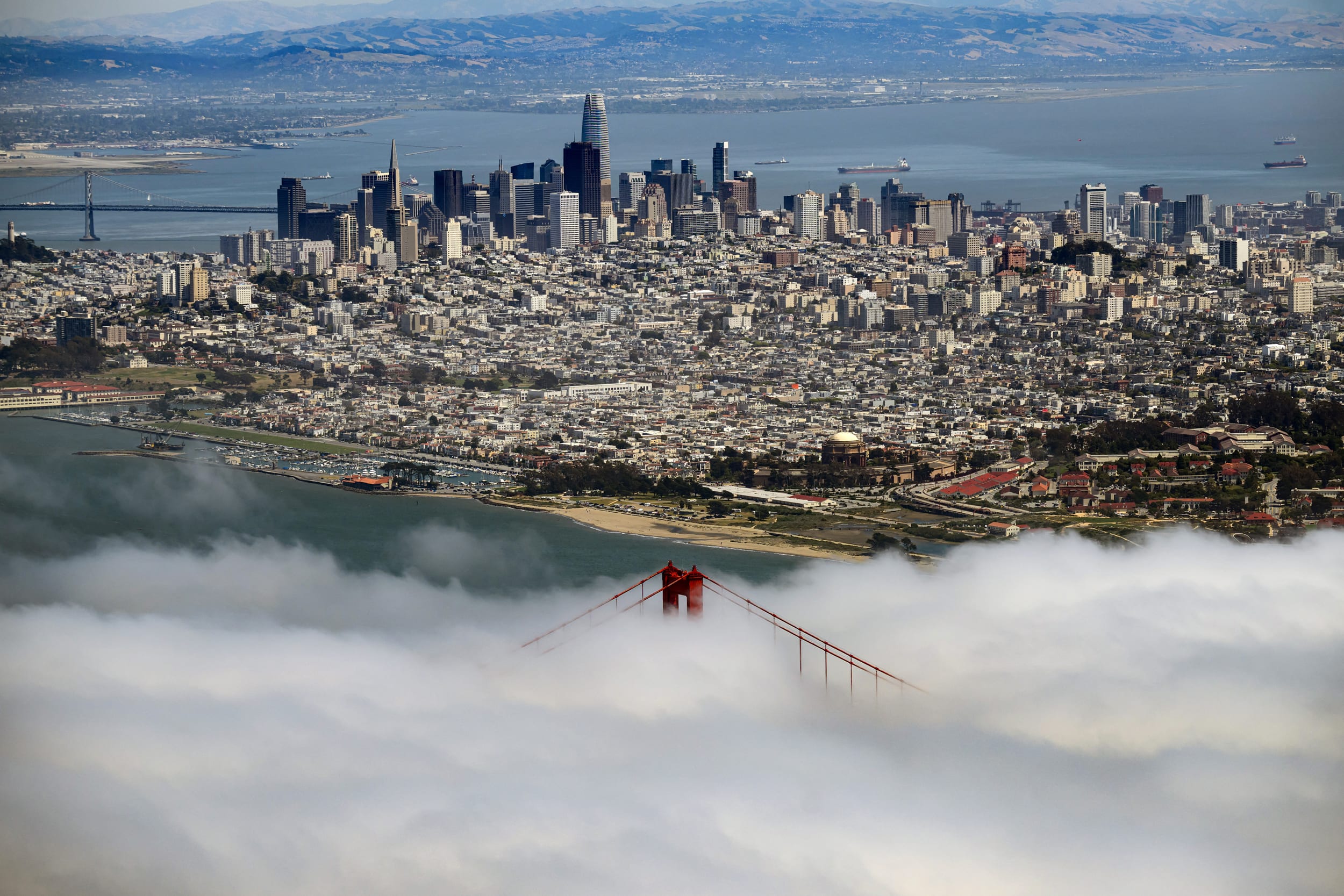 Aerial view, fog rolls by the Golden Gate Bridge.