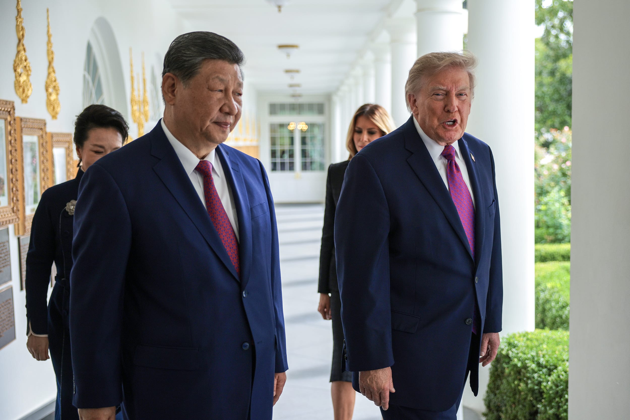 President Trump and President Xi Jinping walking along the White House colonade with their wives behind them.