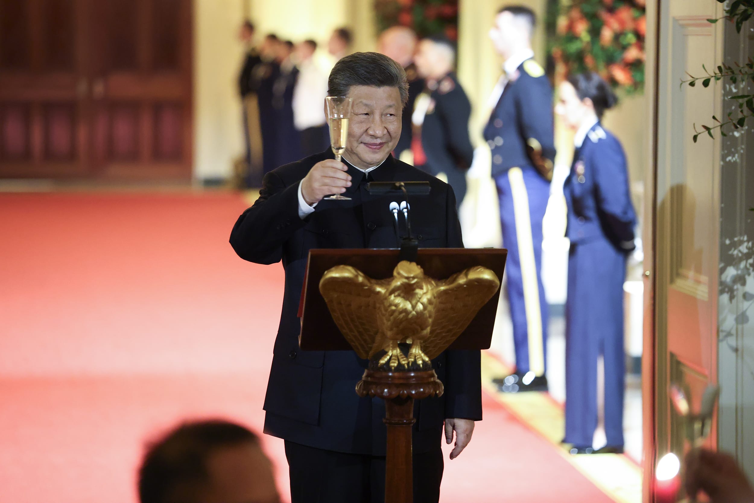 Xi Jinping holds up a champagne flute for a toast during a state dinner.