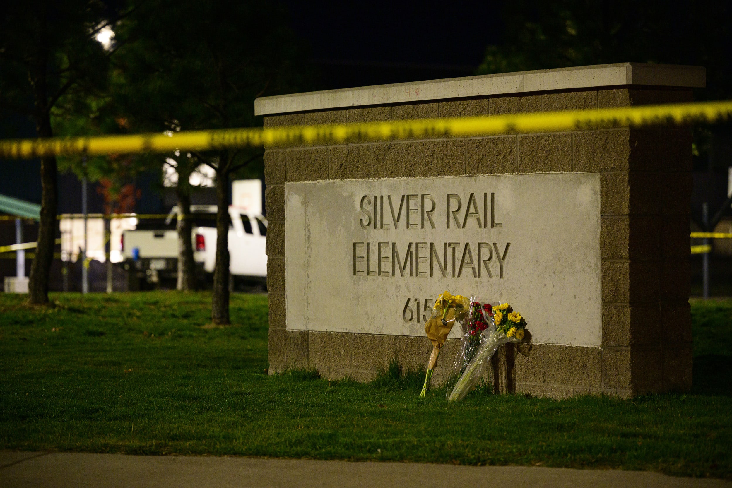 Flowers rest on a sign in front of Silver Rail Elementary School on October 15, 2026 in Bend, Ore.