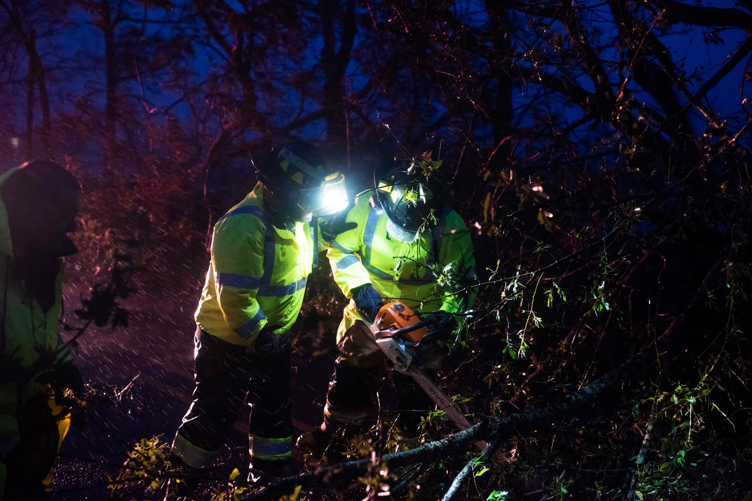Montegut and Bourg firefighters cut through trees on the road in Bourg, La., as Hurricane Ida passes on Sunday.