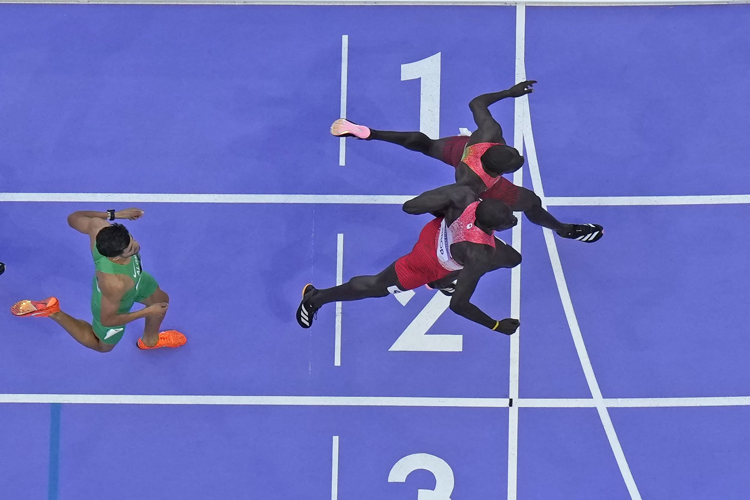 Emmanuel Wanyonyi, of Kenya, top, crosses the finish line ahead of Marco Arop, of Canada to win the men's 800-meter final.