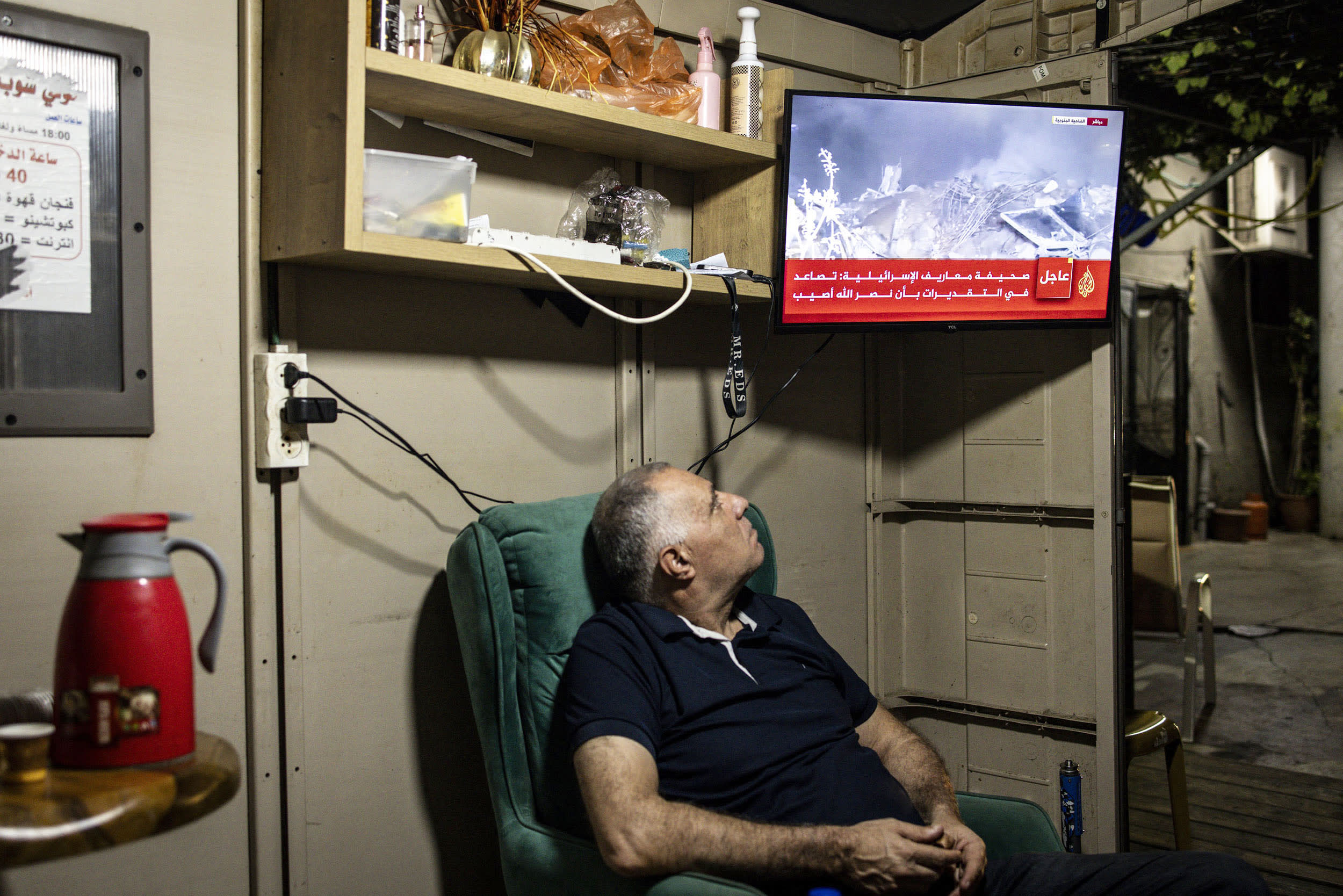 Image: A man watches news coverage on a television.