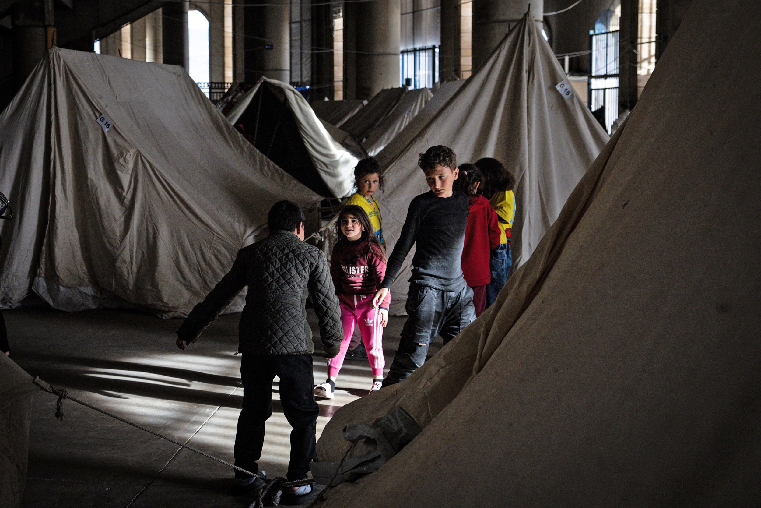 Displaced children play amid tents at a temporary displacement camp setup in the Beirut Stadium on March 28, 2026.