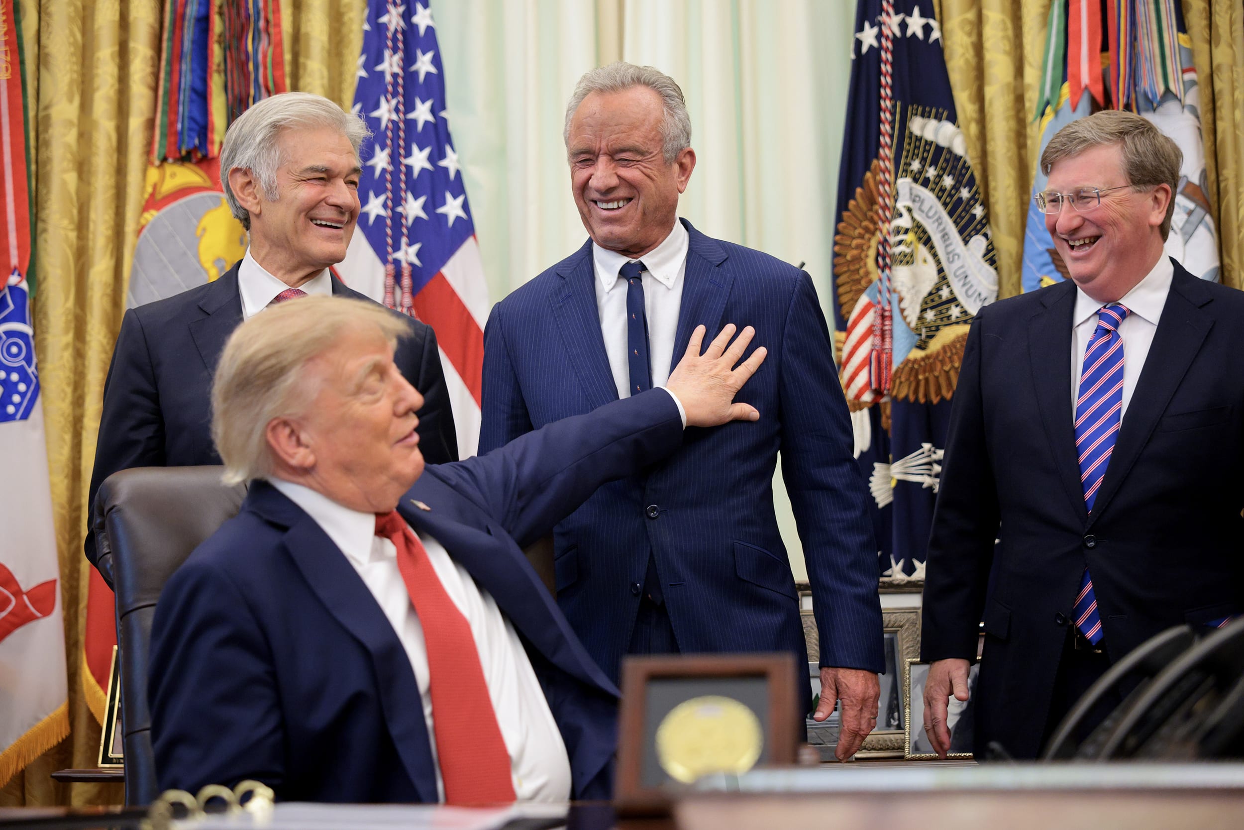 Donald Trump and cabinet aides laugh in the Oval Office
