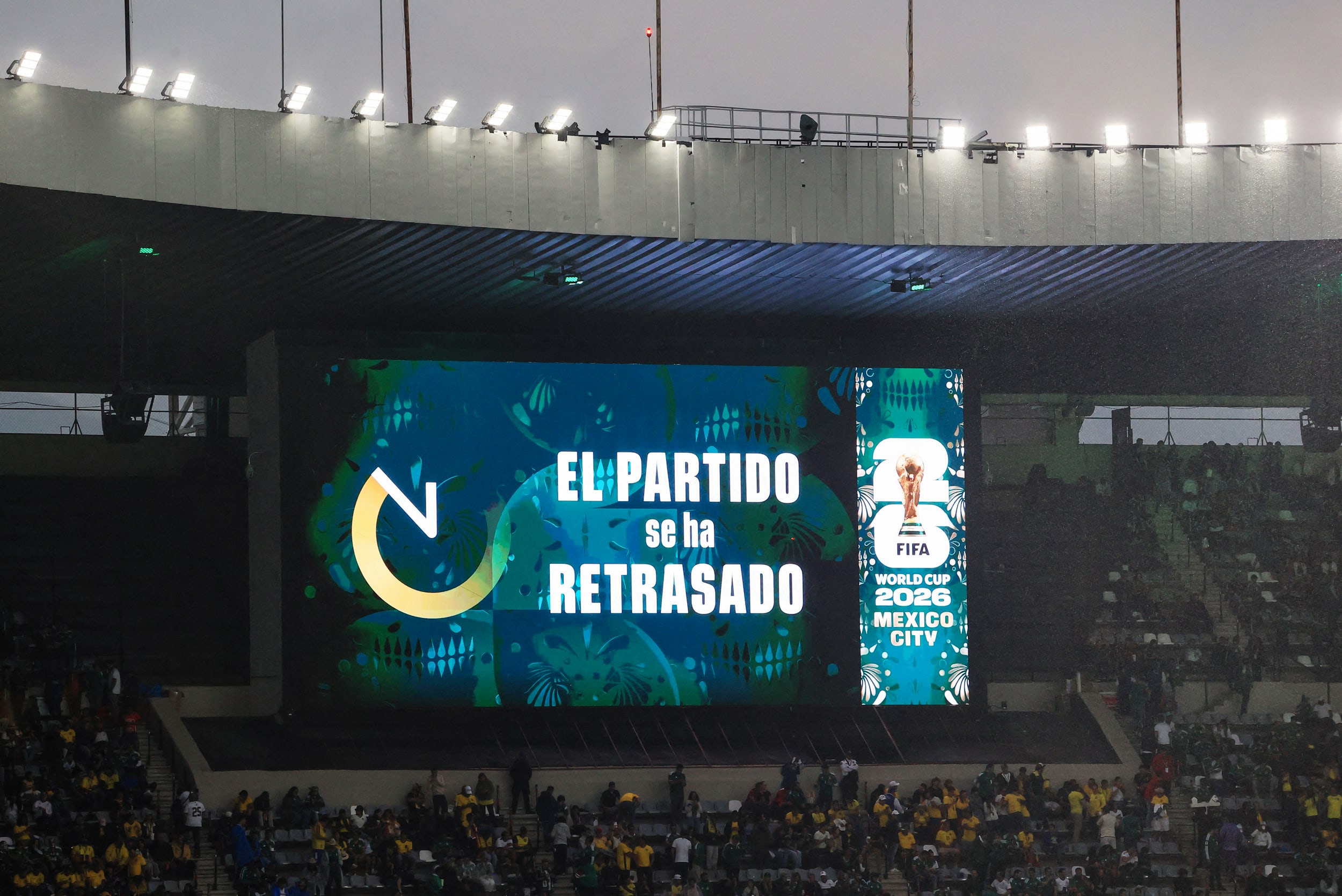 The big screen inside the stadium displays a message saying "the match has been delayed". 