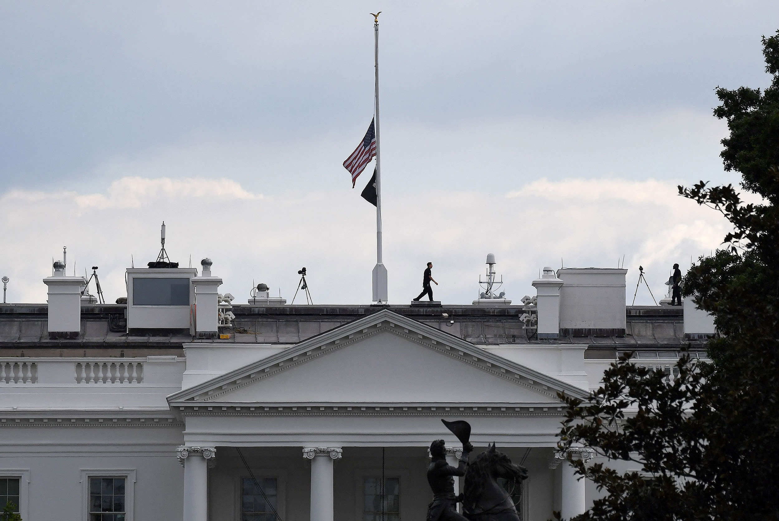 Image: A man walks away after lowering the U.S. flag to half-mast at the White House on Thursday.