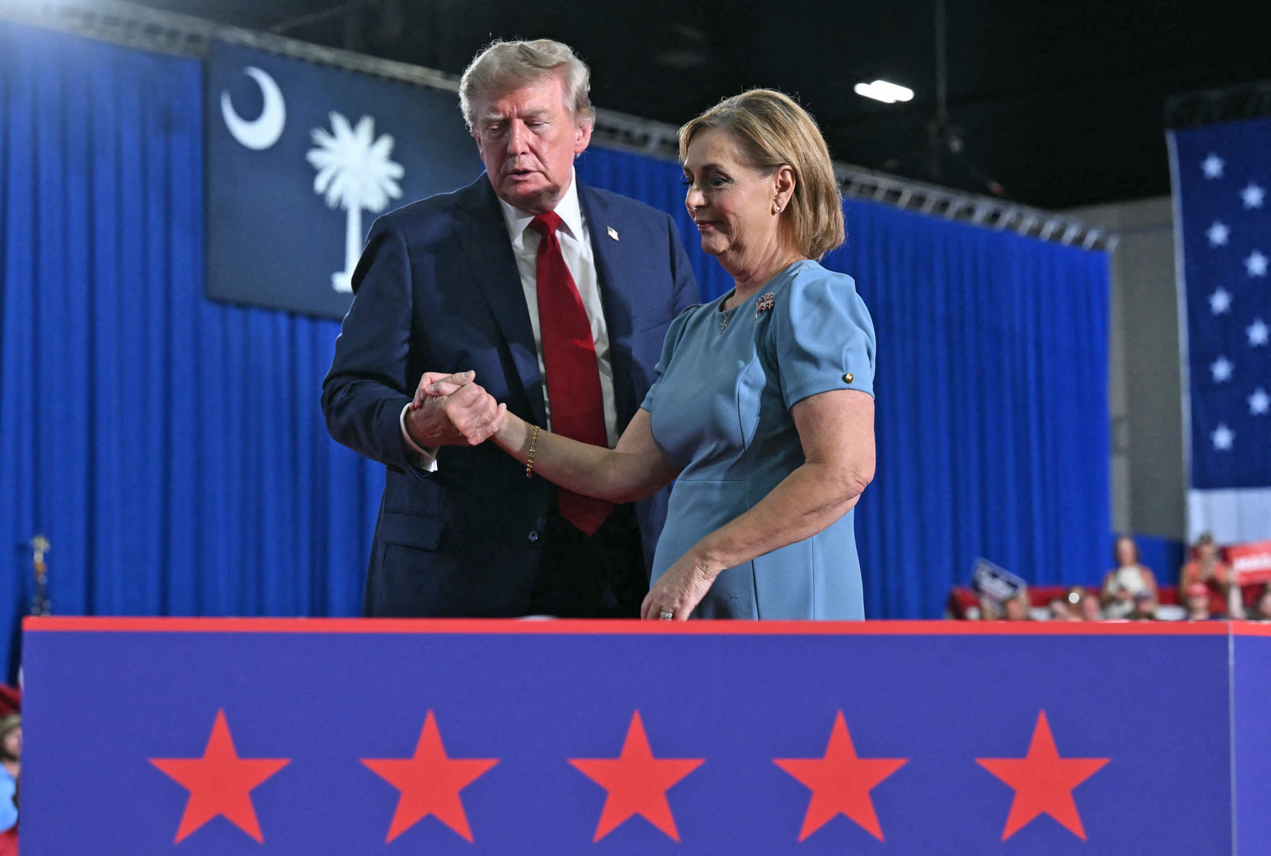President Donald Trump helps Sen. Darline Graham off the stage during a campaign rally in Myrtle Beach, S.C., on Aug. 21, 2026. 