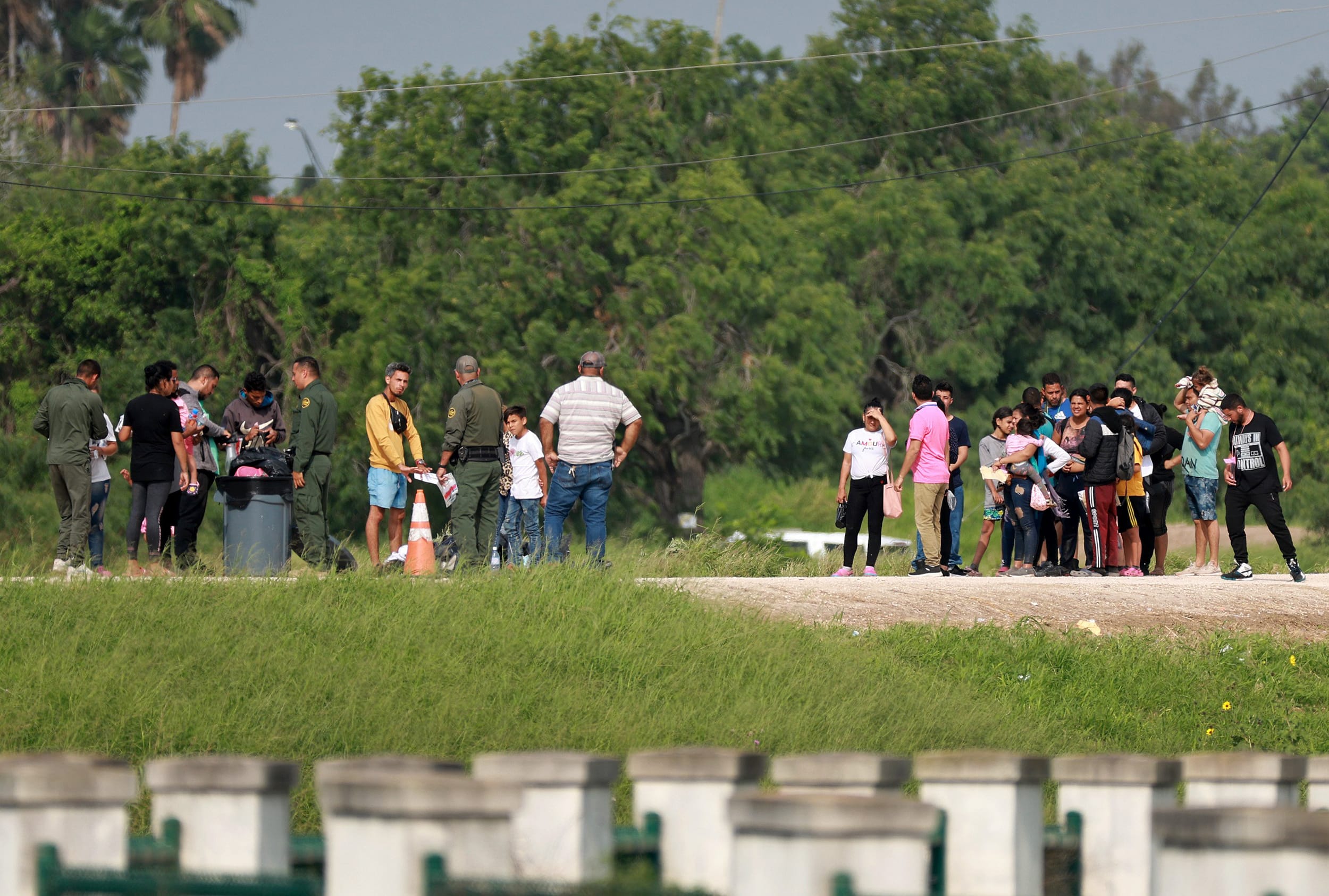 Migrants walk to where the United States Border Patrol is processing them in Brownsville, Texas, after they crossed into the U.S. from Mexico on May 10, 2023.