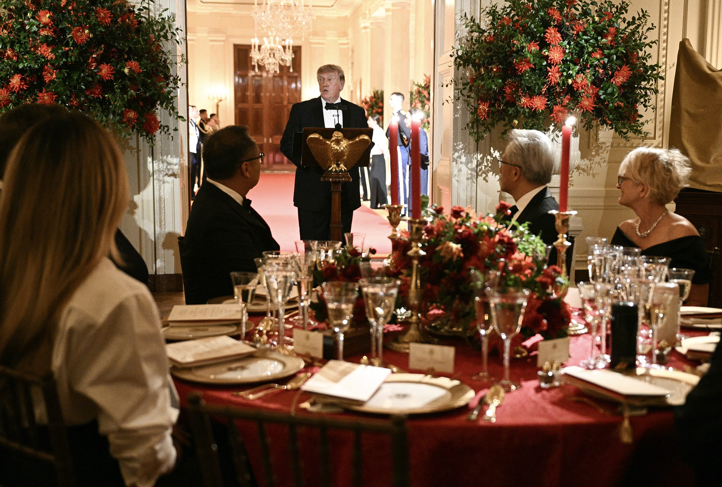 Donald Trump speaks at a lectern during a state dinner.
