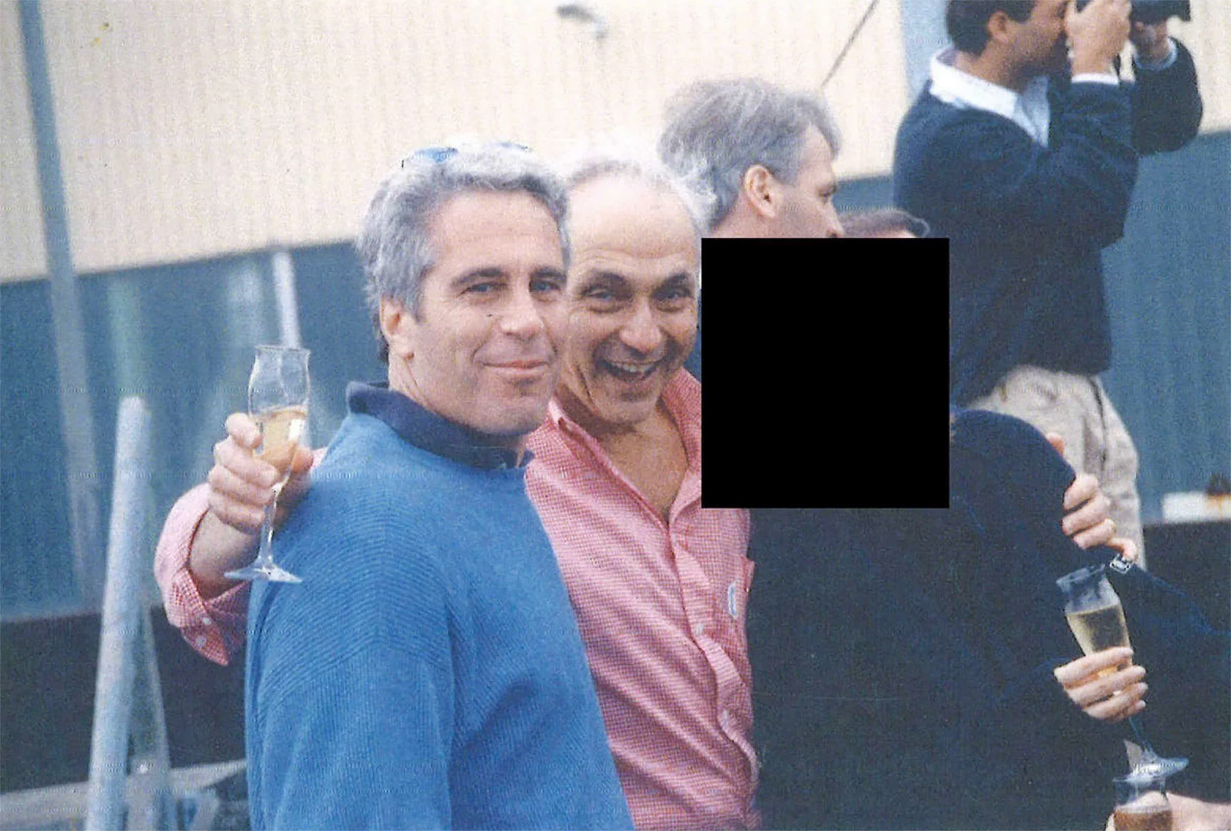 Jeffrey Epstein, Les Wexner and a person who has been redacted pose together in an undated photo.