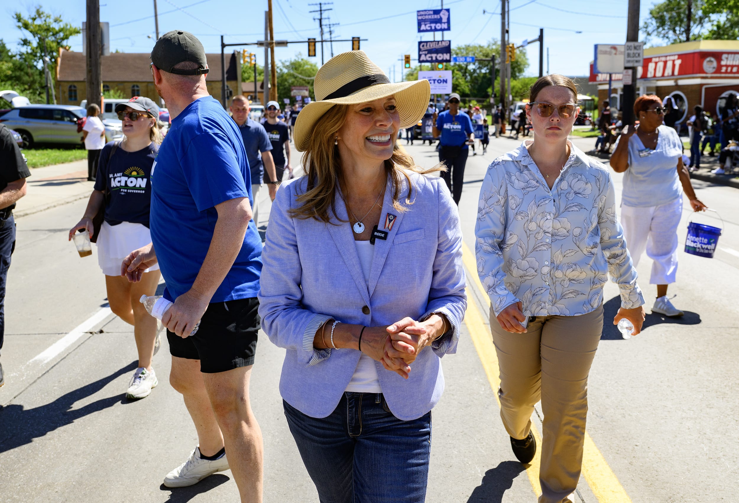 Amy Acton walking in a parade flanked by staffers.