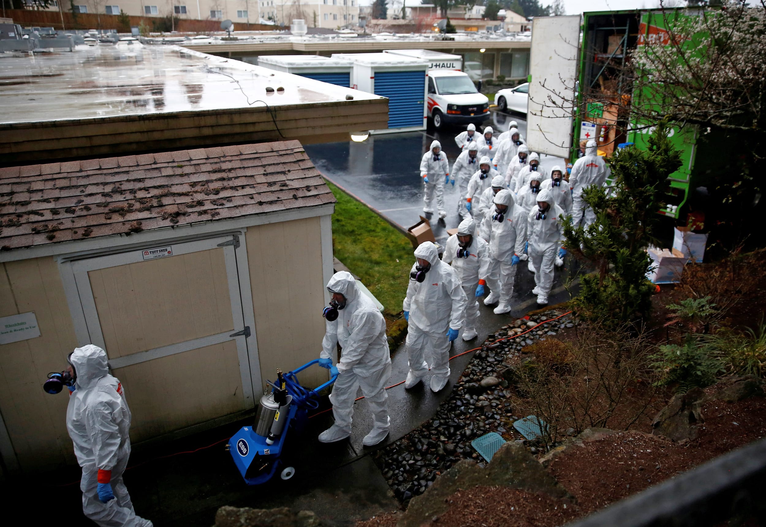 Image: Servpro workers file in to begin a third day of cleaning at Life Care Center of Kirkland