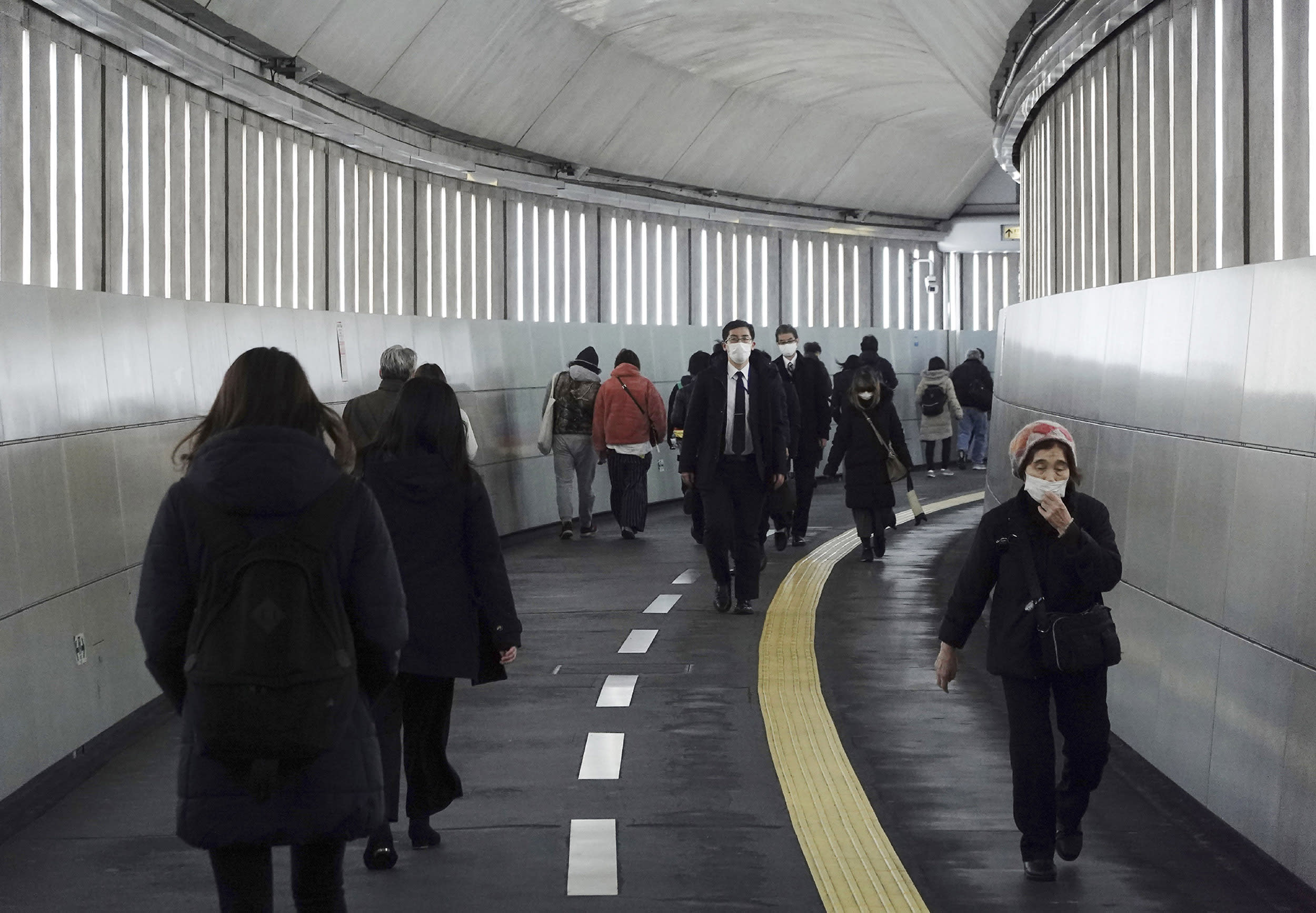 Image: People wearing protective masks to help curb the spread of the coronavirus walk along an underpass Tuesday, Jan. 26, 2021, in Tokyo.