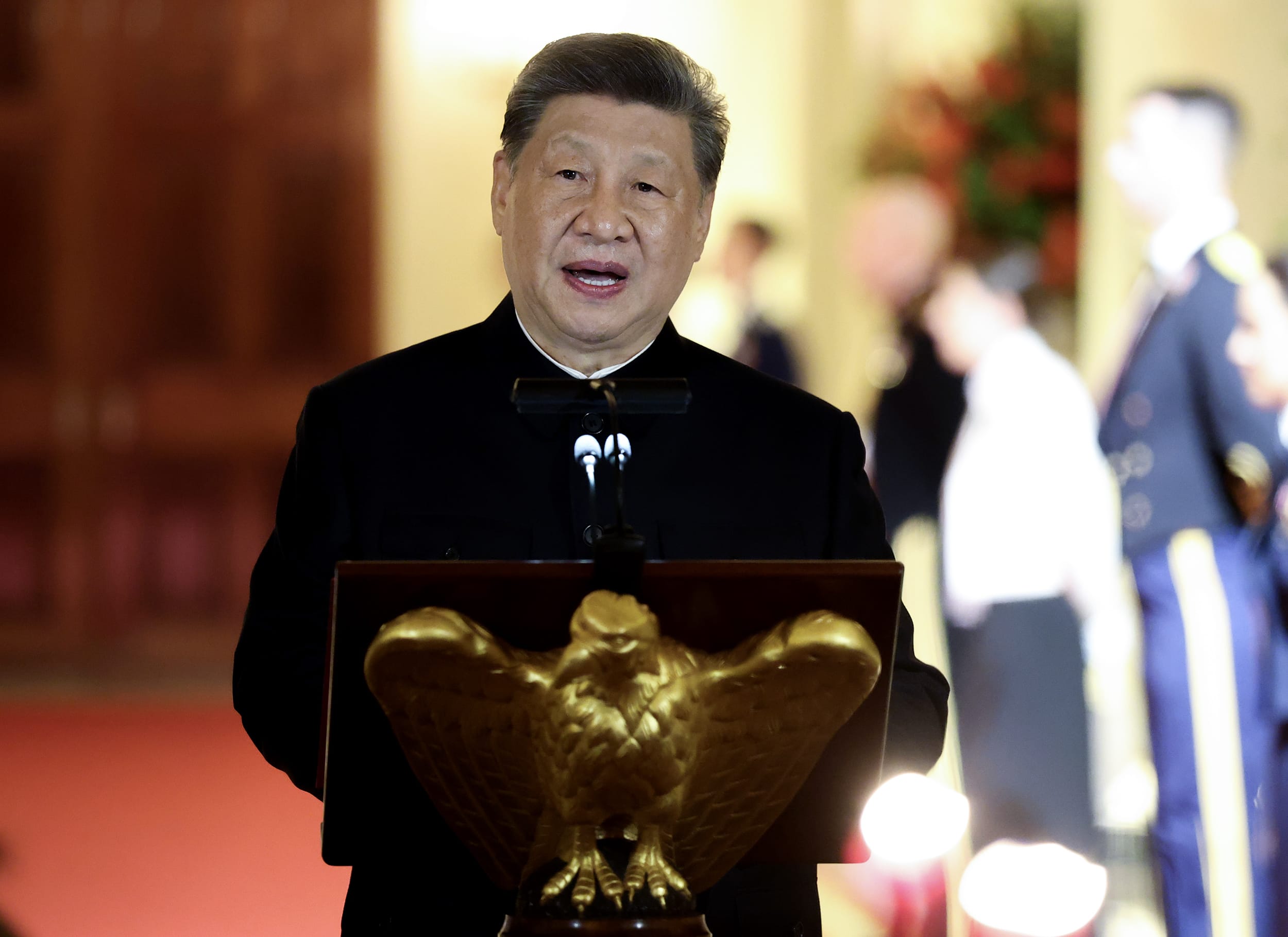 Xi Jinping speaks at a wooden lectern embossed with a golden eagle.